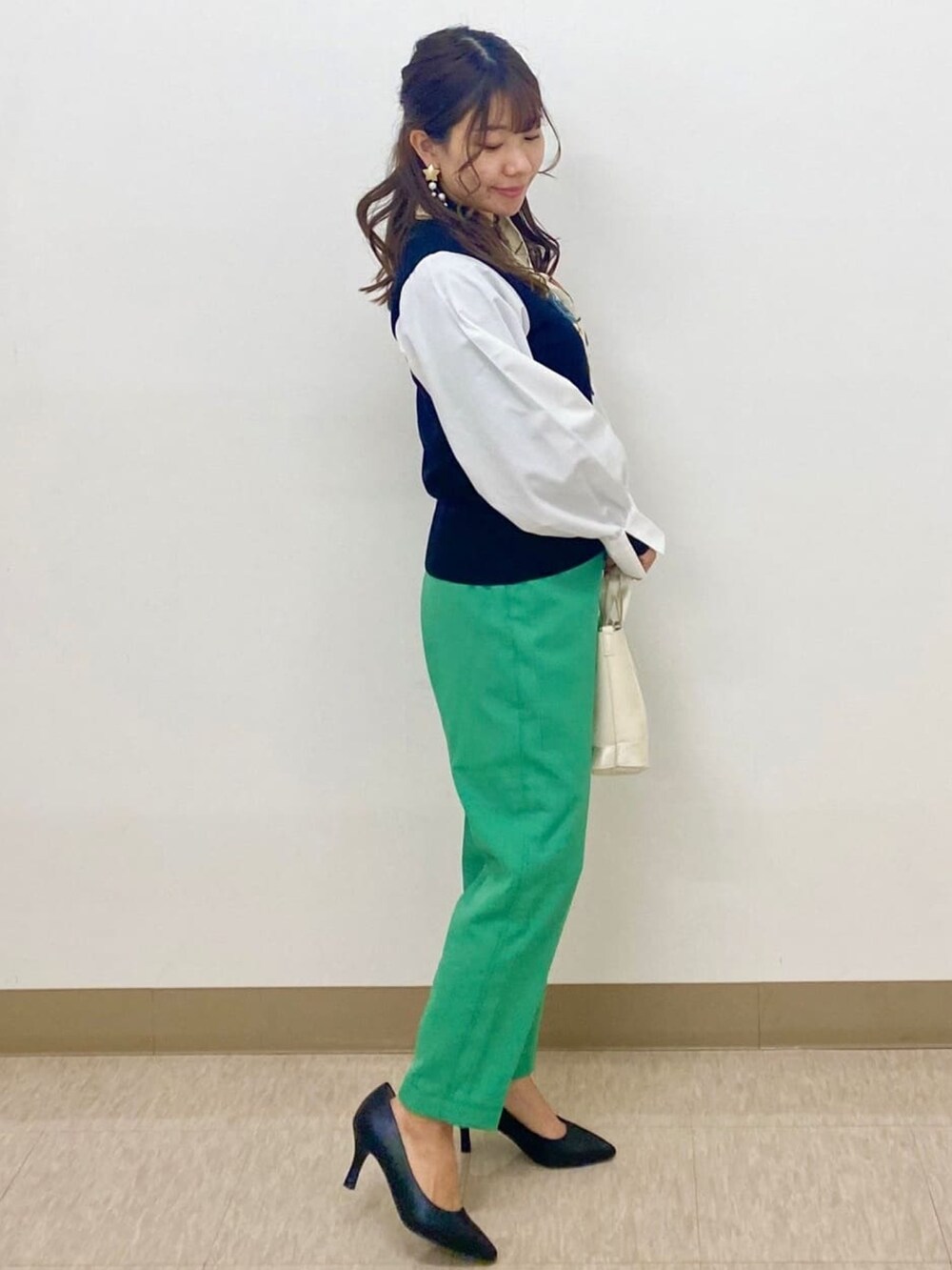 ブラック系のニット/セーター、グリーン系のその他パンツ、ブラック系のパンプスを着用したレディースの春コーディネートの2枚目の写真