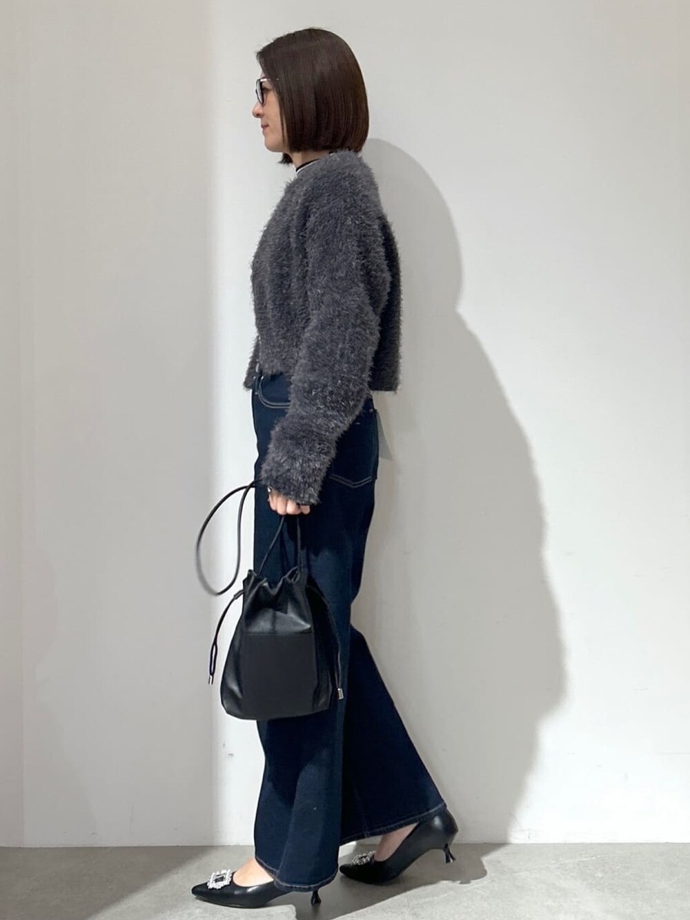 グレー系のカーディガン/ボレロ、ブルー系のその他パンツ、ブラック系のショルダーバッグを着用したレディースの冬コーディネートの4枚目の写真