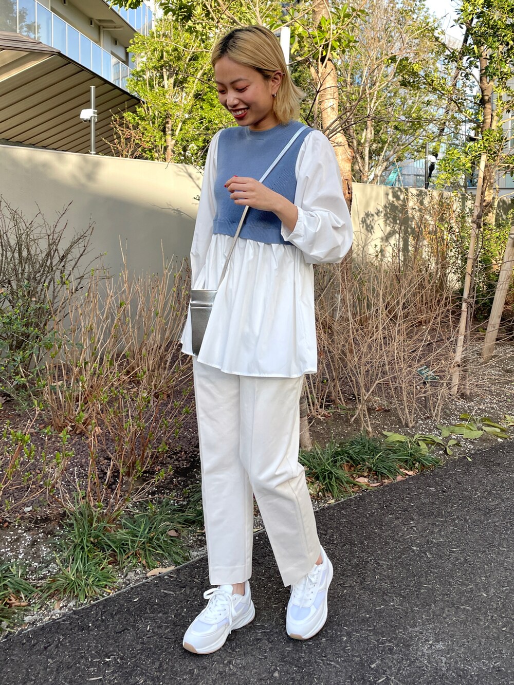 ブルー系のニット/セーター、ホワイト系のその他パンツ、ホワイト系のスニーカーを着用したレディースの春コーディネートの2枚目の写真