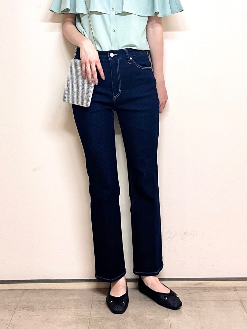 グリーン系のシャツ/ブラウス、ブラック系のパンプス、ブルー系のデニムパンツを着用したレディースの夏コーディネートの6枚目の写真