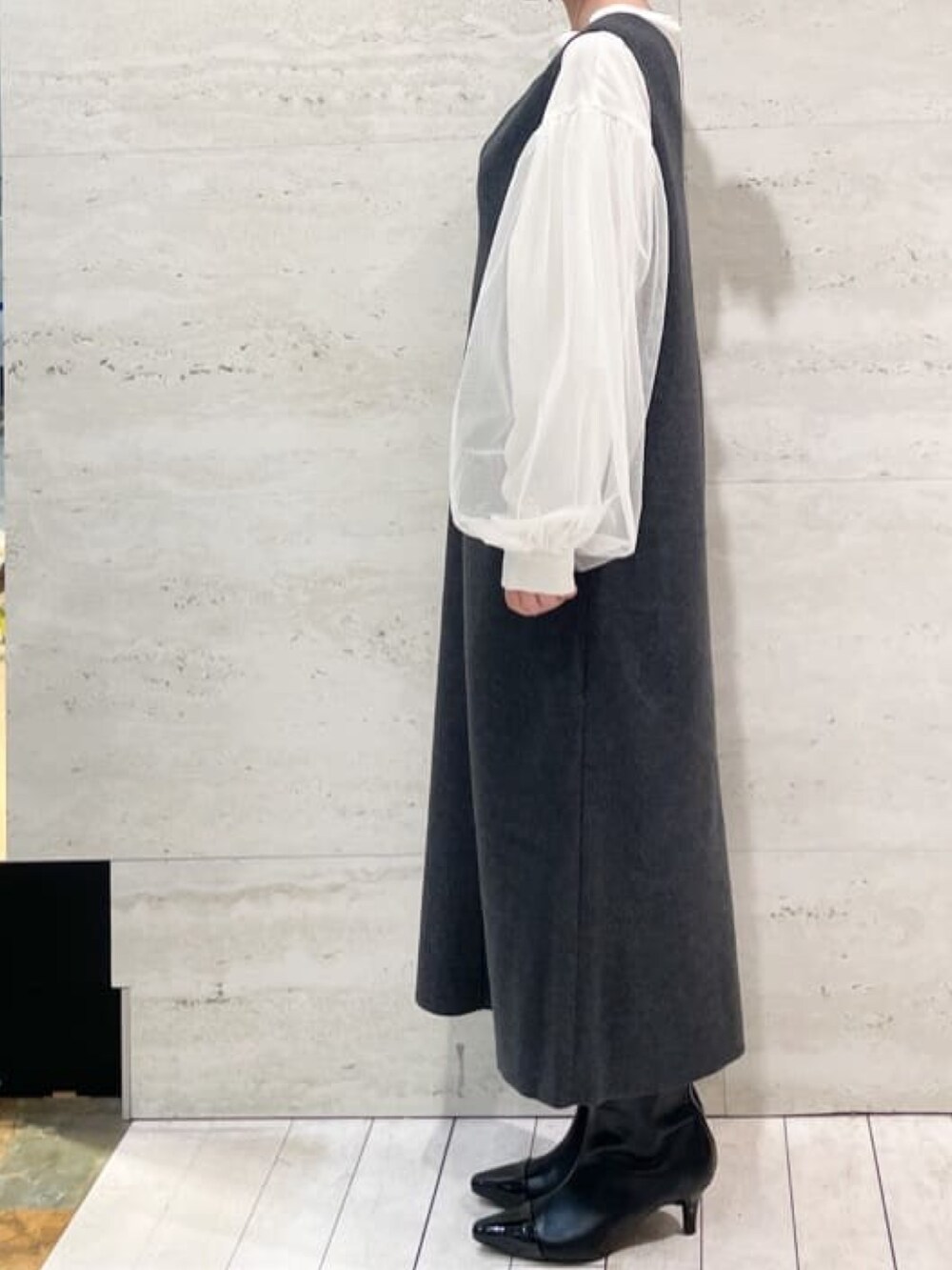 ブラック系のショルダーバッグ、ブラック系のブーツ、ホワイト系のシャツ/ブラウスを着用したレディースの秋コーディネートの2枚目の写真