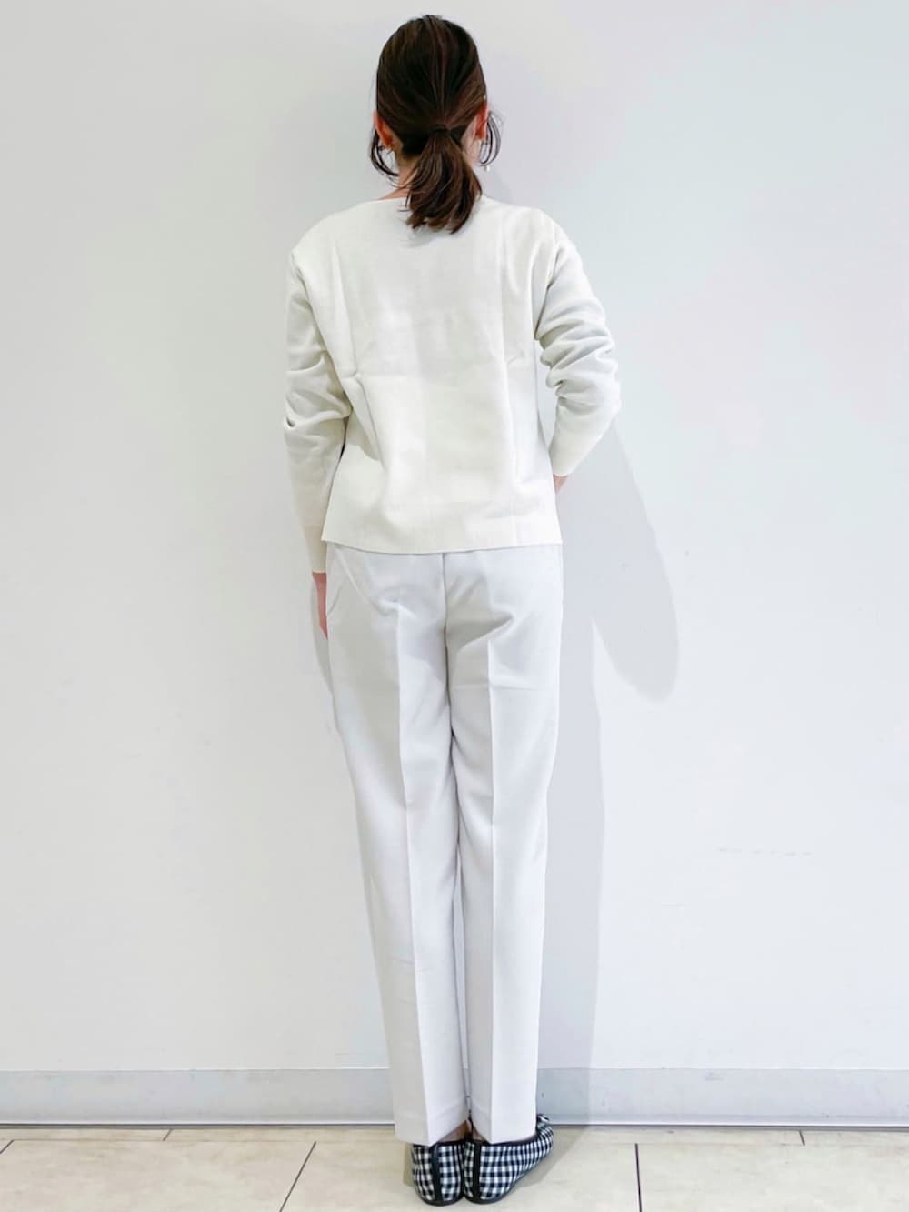 ホワイト系のニット/セーター、グレー系のその他パンツ、ブラック系のその他シューズを着用したレディースの冬コーディネートの2枚目の写真