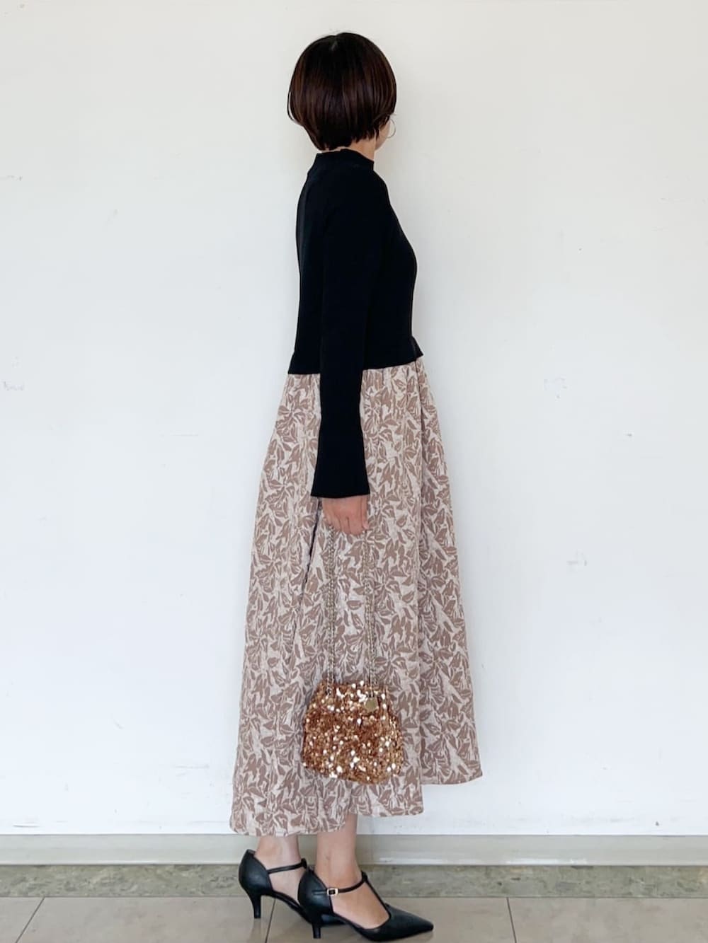 ベージュ系のワンピース、ブラウン系のショルダーバッグ、ブラック系のパンプスを着用したレディースの秋コーディネートの3枚目の写真