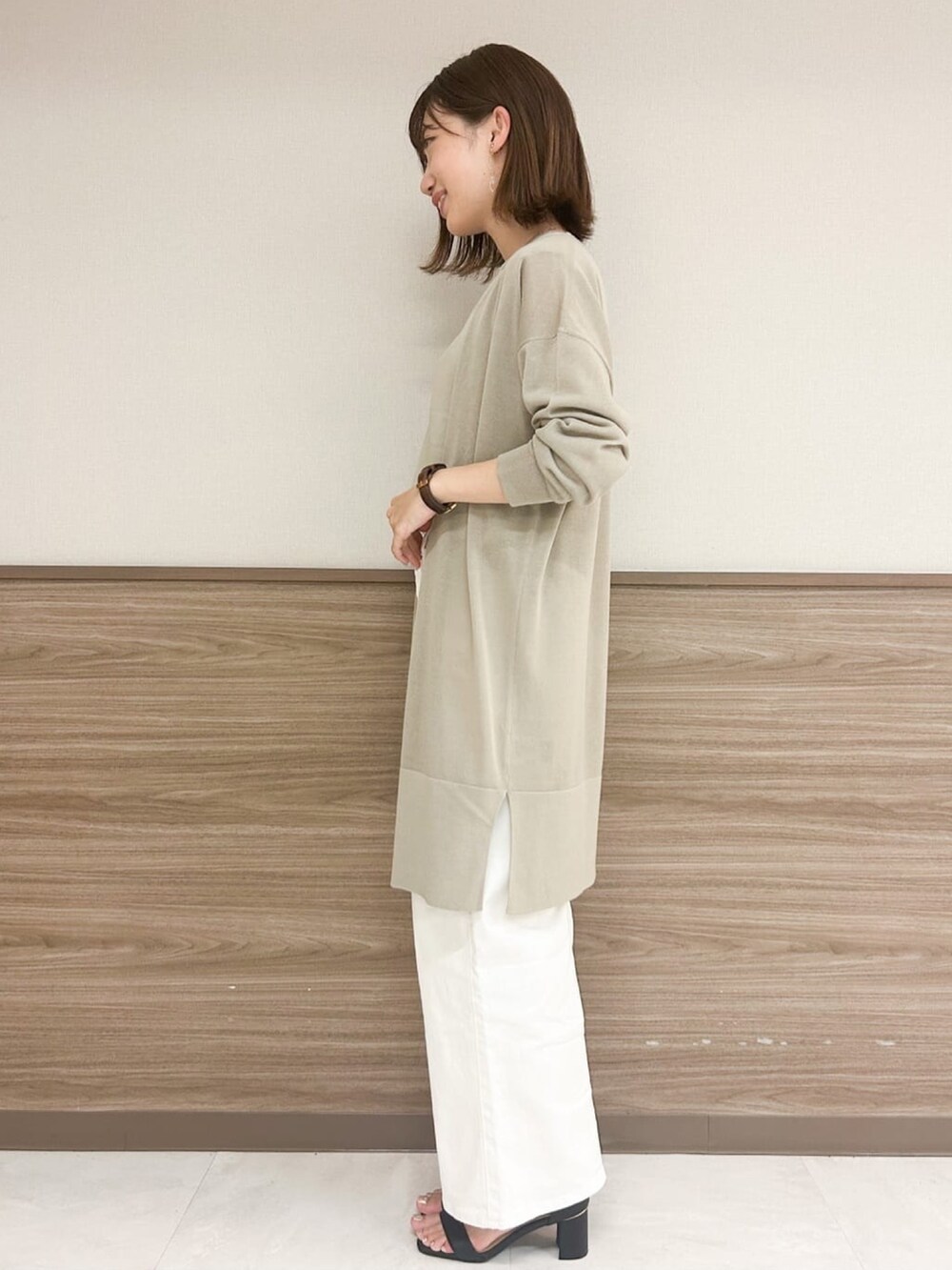 ブラック系のサンダル、ブラック系のショルダーバッグ、ベージュ系のTシャツ/カットソーを着用したレディースの夏コーディネートの2枚目の写真