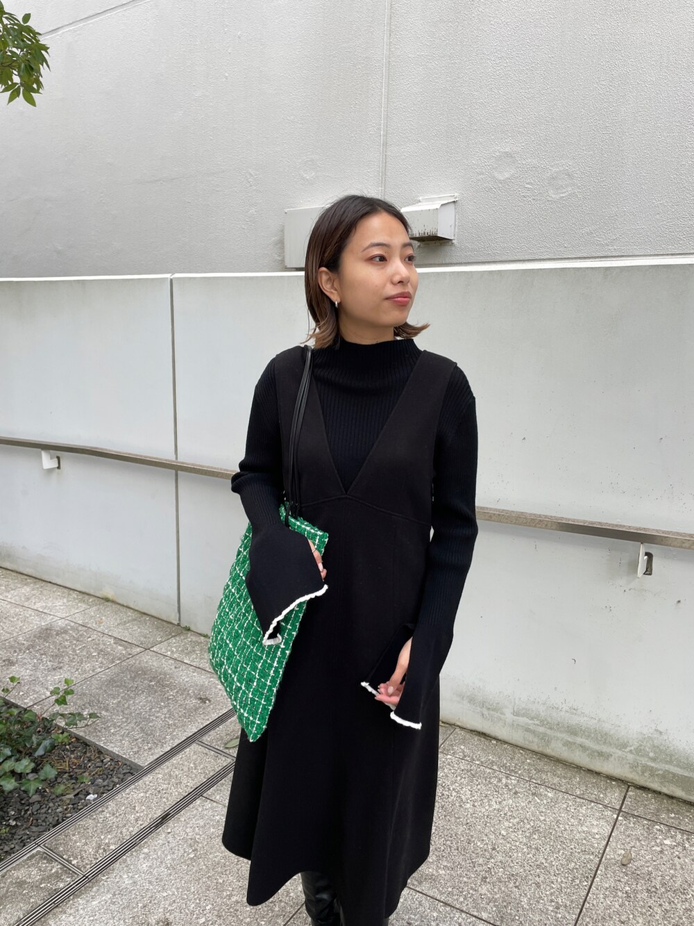 ブラック系のニット/セーター、ブラック系のスカート、グリーン系のトートバッグを着用したレディースの冬コーディネートの5枚目の写真
