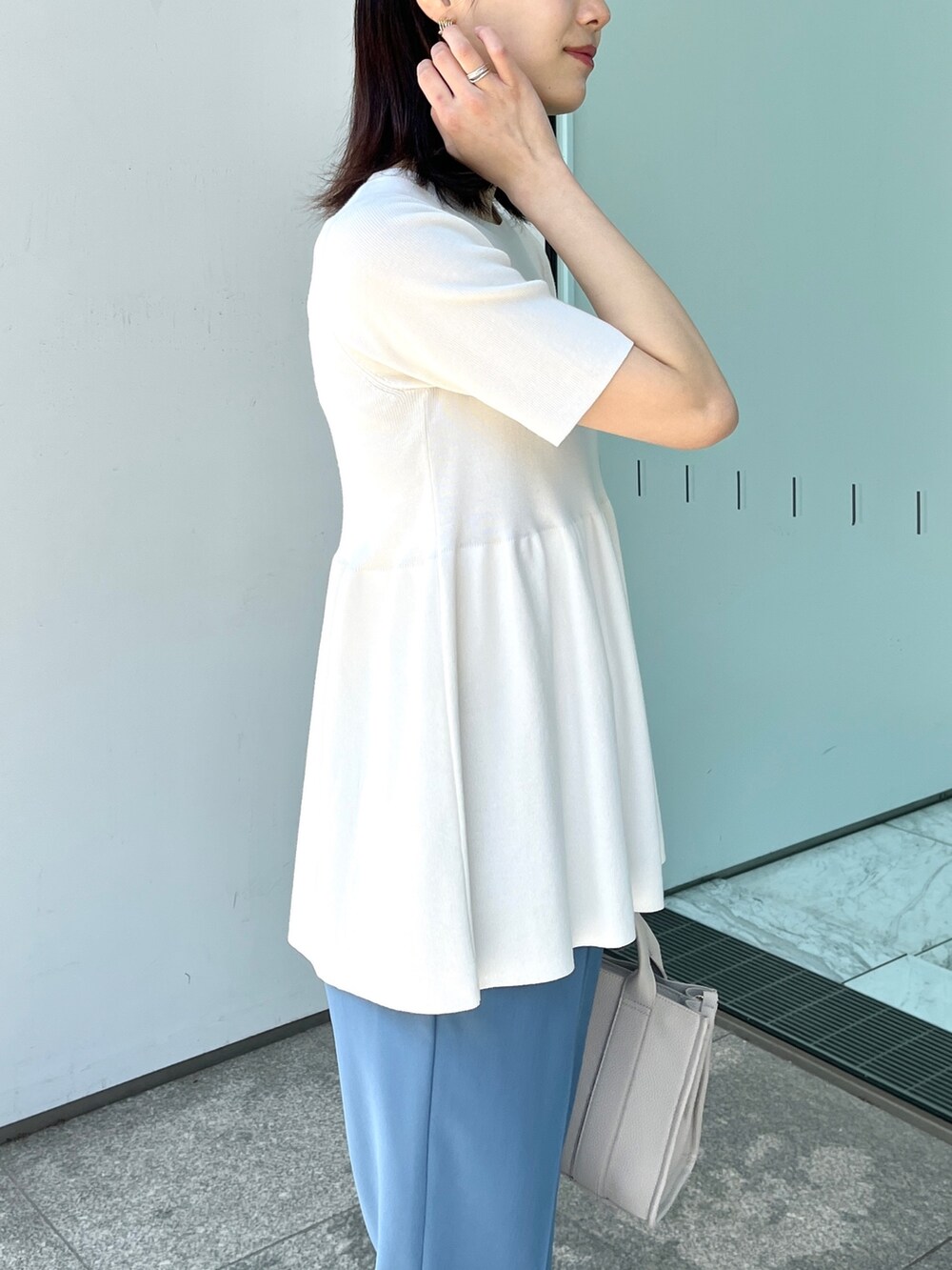 ホワイト系のニット/セーター、ブルー系のその他パンツ、ゴールド系のサンダルを着用したレディースの春コーディネートの5枚目の写真