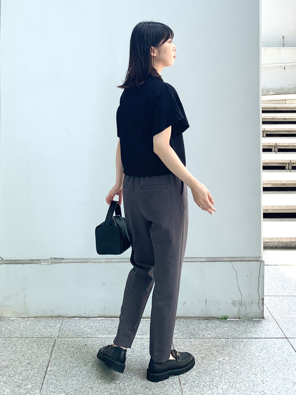 ブラック系のニット/セーター、ブラック系のその他パンツ、ブラック系のシューズを着用したレディースの夏コーディネートの3枚目の写真