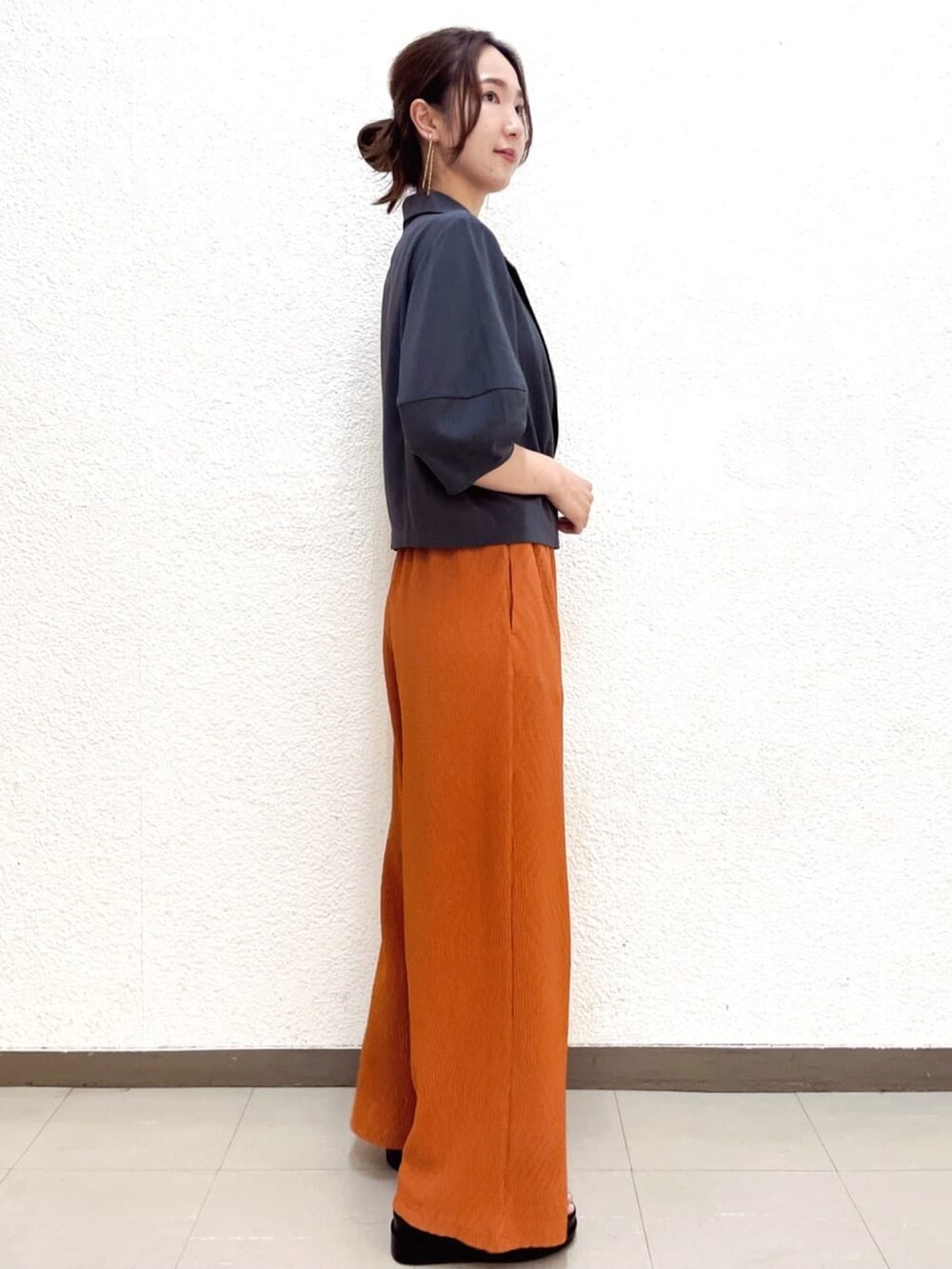 ホワイト系のタンクトップ、グレー系のテーラードジャケット、レッド系のその他パンツを着用したレディースの夏コーディネートの4枚目の写真