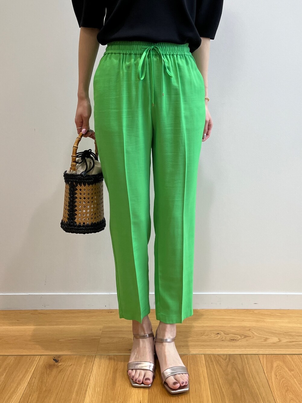 ブラック系のニット/セーター、ゴールド系のサンダル、ブラック系のトートバッグを着用したレディースの春コーディネートの6枚目の写真