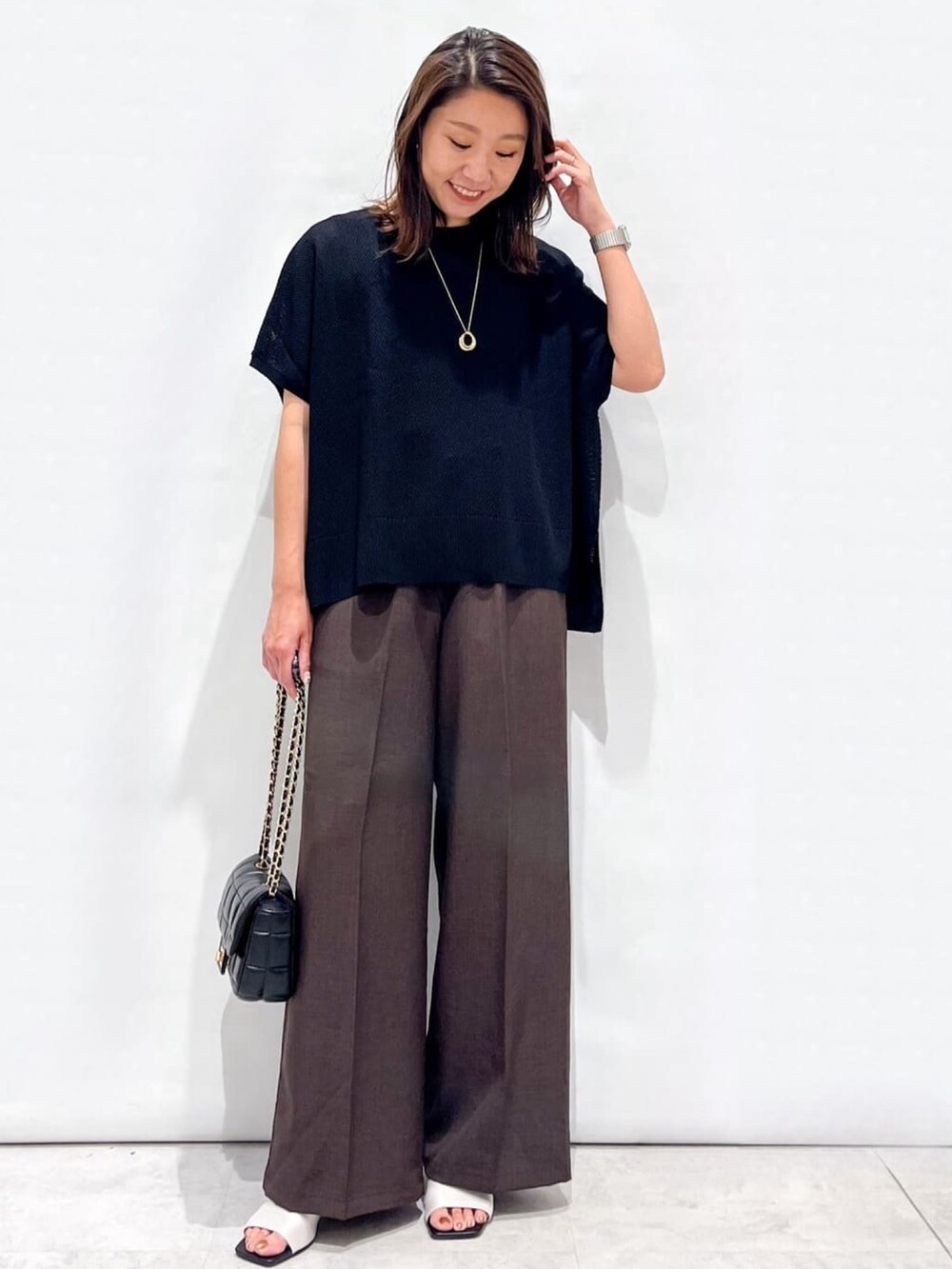 ブラウン系のその他パンツ、ホワイト系のサンダル、ブラック系のショルダーバッグを着用したレディースの夏コーディネートの6枚目の写真