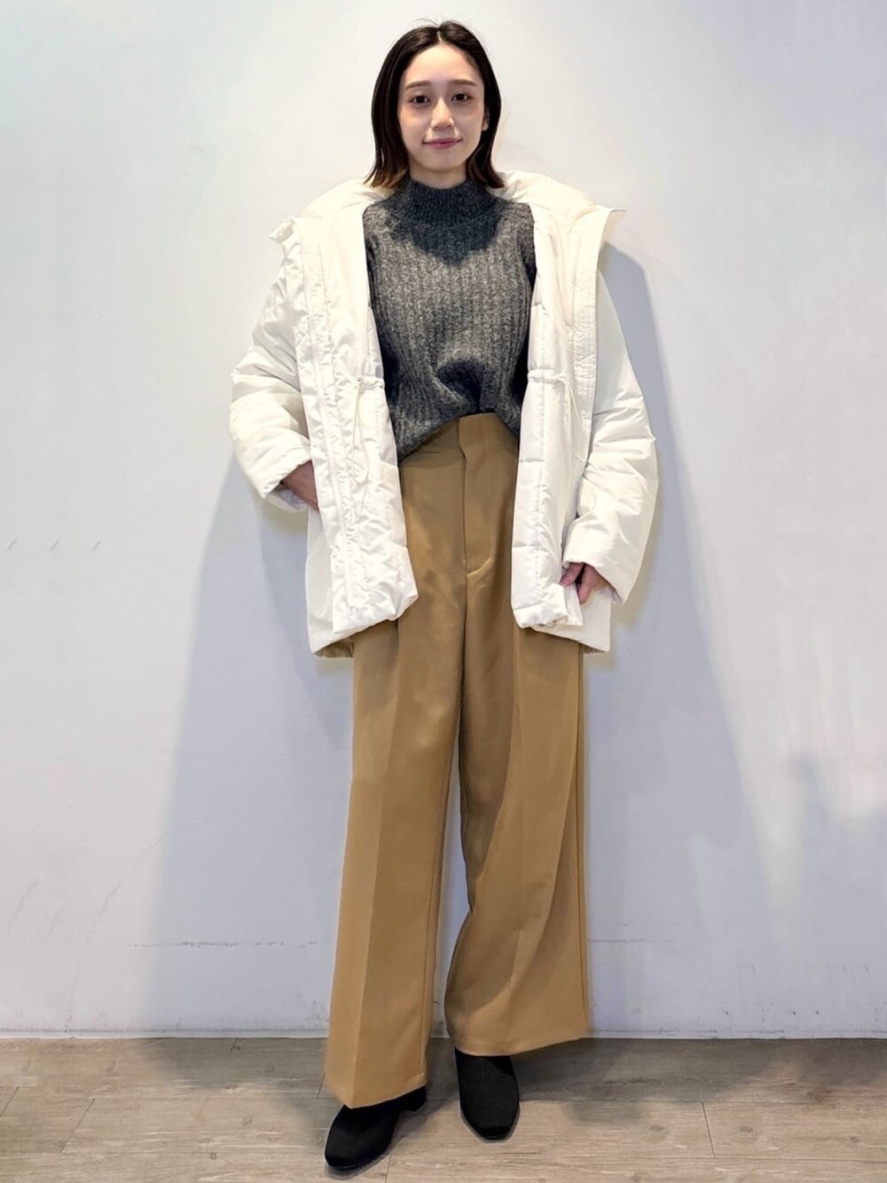 イエロー系のその他パンツ、グレー系のニット/セーター、ホワイト系のその他アウターを着用したレディースの冬コーディネートの2枚目の写真