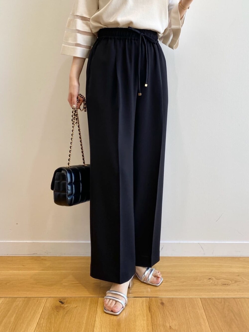 ホワイト系のニット/セーター、ブラック系のその他パンツ、ブラック系のショルダーバッグを着用したレディースの春コーディネートの9枚目の写真