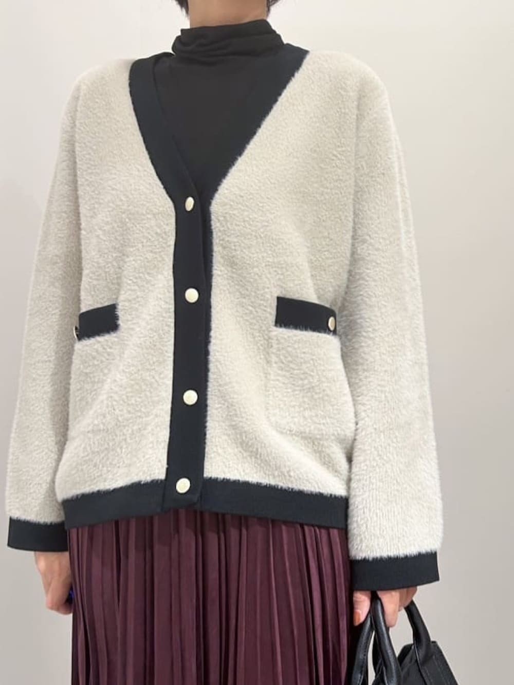 ベージュ系のカーディガン/ボレロ、ブラック系のTシャツ/カットソー、ブラック系のブーツを着用したレディースの秋コーディネートの3枚目の写真