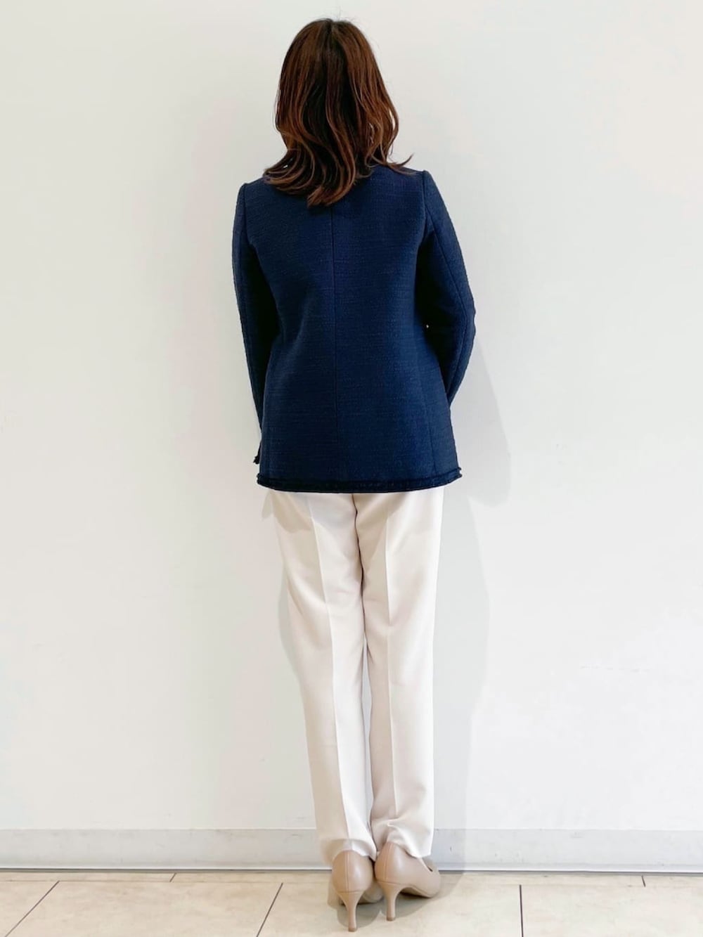 ブルー系のノーカラージャケット、ブラック系のパンプス、ベージュ系のその他パンツを着用したレディースの春コーディネートの3枚目の写真