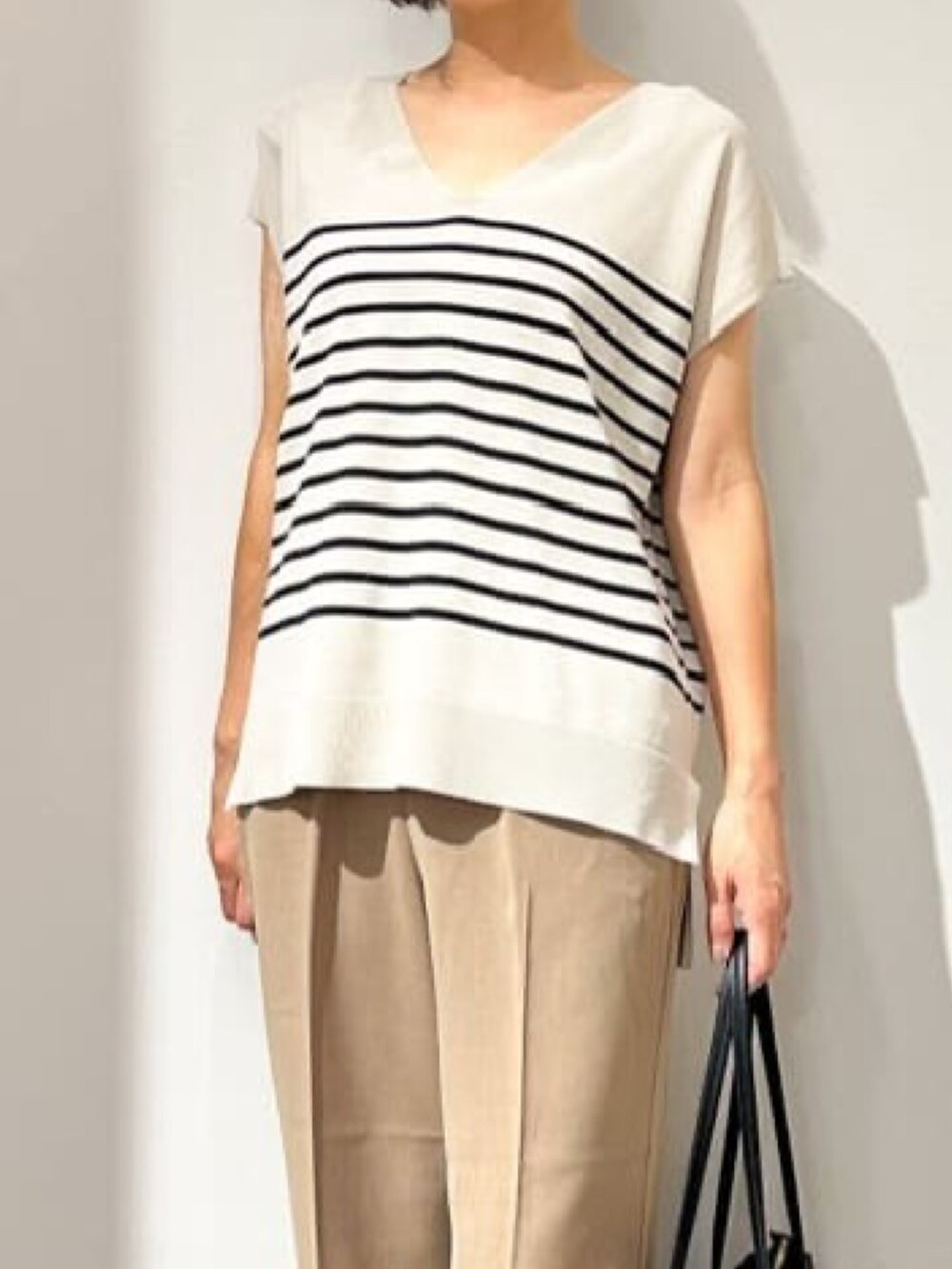 ベージュ系のニット/セーター、イエロー系のその他パンツ、ブラック系のパンプスを着用したレディースの夏コーディネートの3枚目の写真