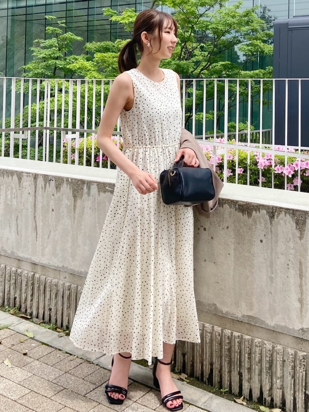 ブラウン系のベスト、ホワイト系のワンピース、ブラック系のサンダルを着用したレディースの春コーディネートの10枚目の写真