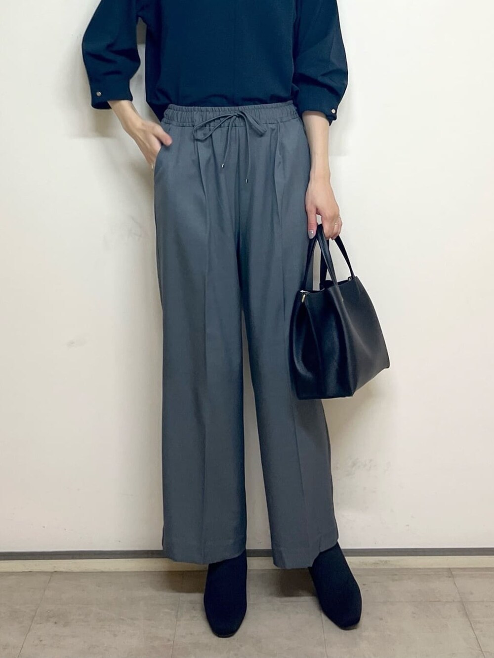 ブルー系のTシャツ/カットソー、グレー系のその他パンツ、ブラック系のトートバッグを着用したレディースの秋コーディネートの6枚目の写真