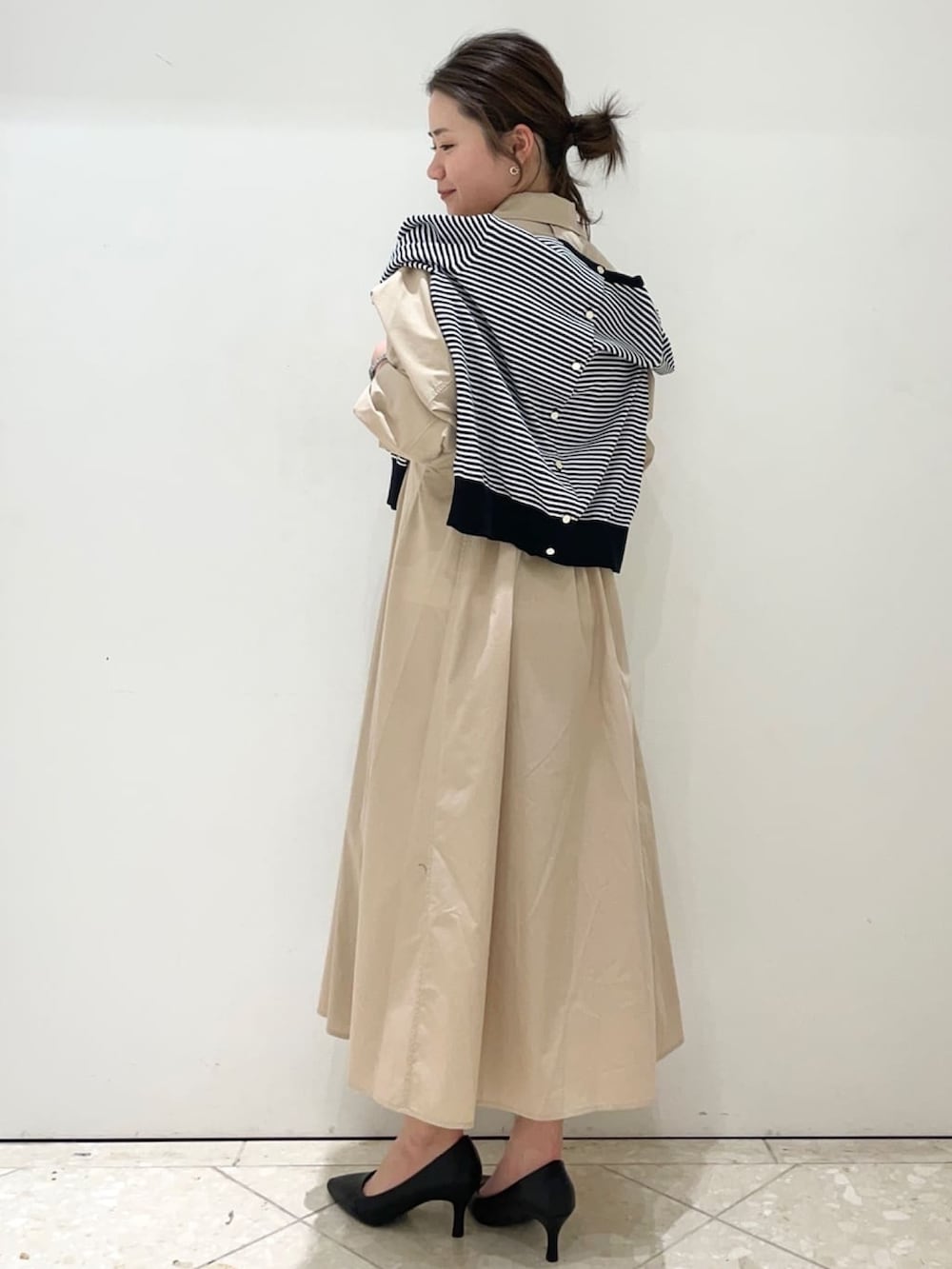 ベージュ系のワンピース、ホワイト系のカーディガン/ボレロ、ブラック系のショルダーバッグを着用したレディースの春コーディネートの3枚目の写真