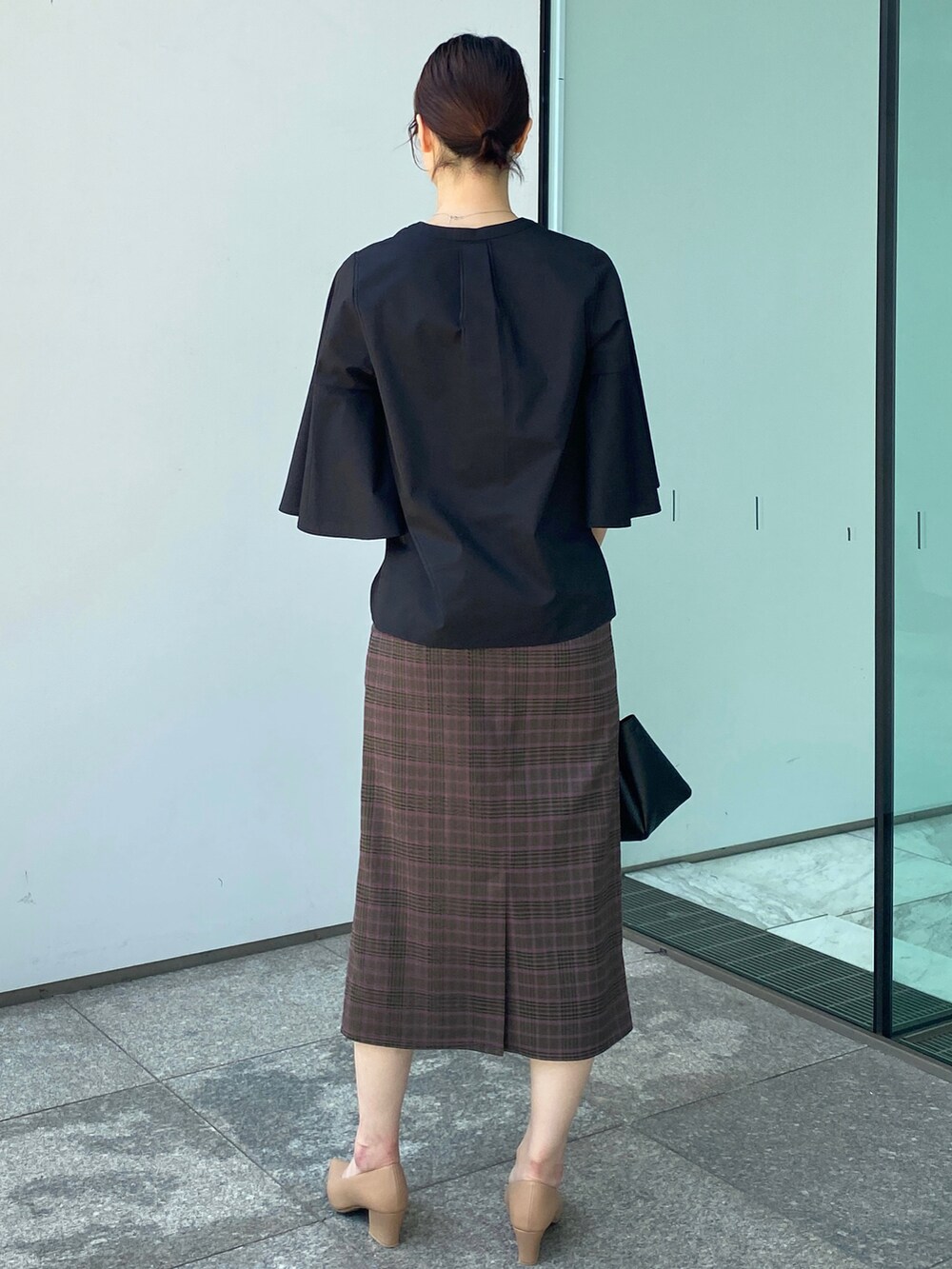 ブラック系のシャツ/ブラウス、ブラウン系のスカート、ベージュ系のパンプスを着用したレディースの夏コーディネートの3枚目の写真