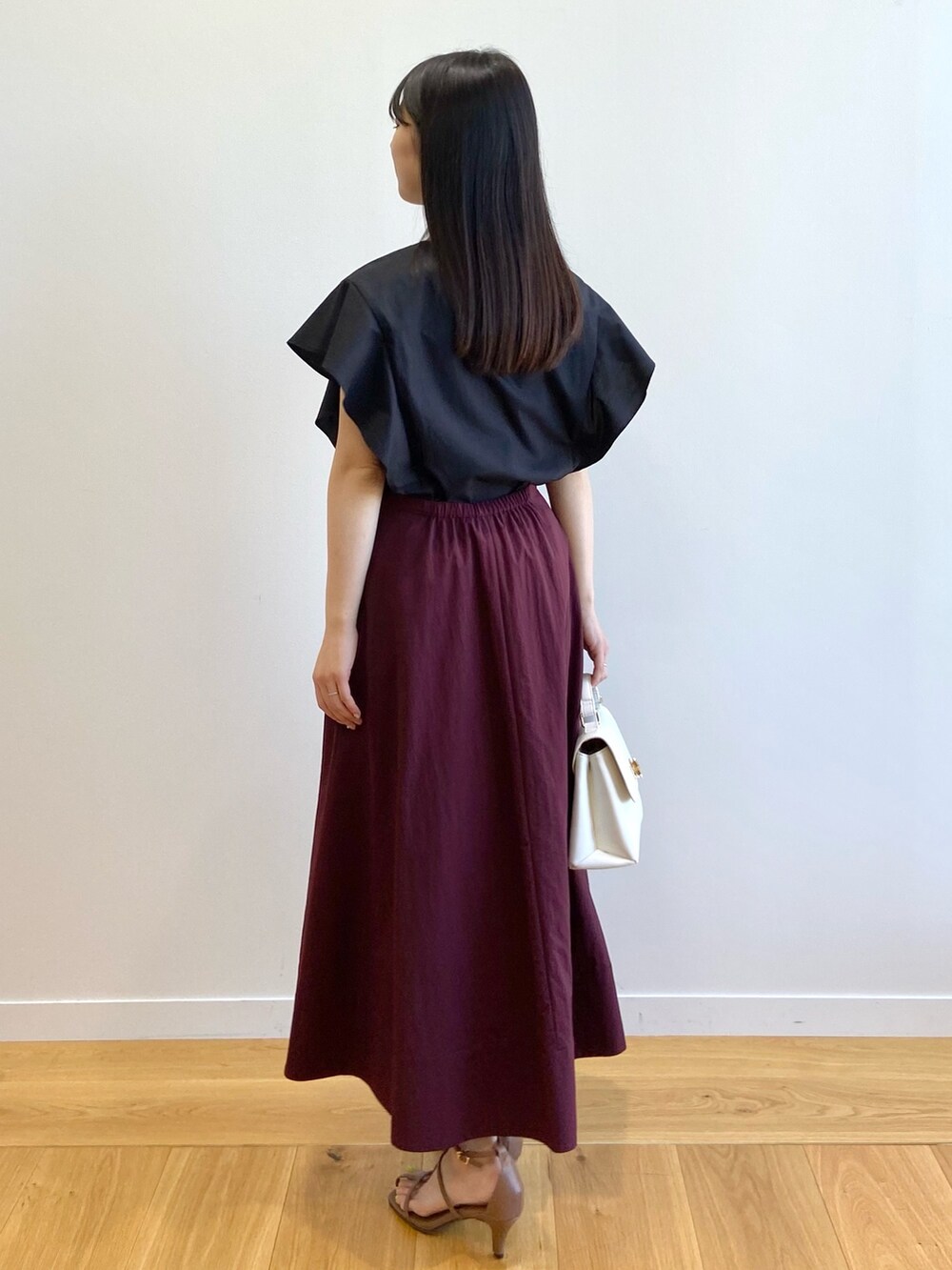 ブラック系のシャツ/ブラウス、レッド系のスカート、ホワイト系のショルダーバッグを着用したレディースの春コーディネートの3枚目の写真