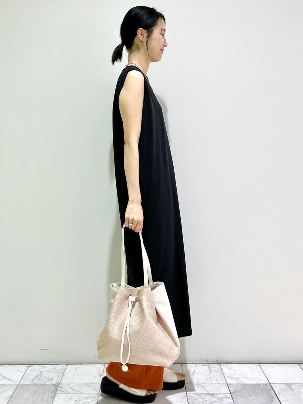 ブラック系のワンピース、レッド系のその他パンツ、ベージュ系のトートバッグを着用したレディースの夏コーディネートの3枚目の写真