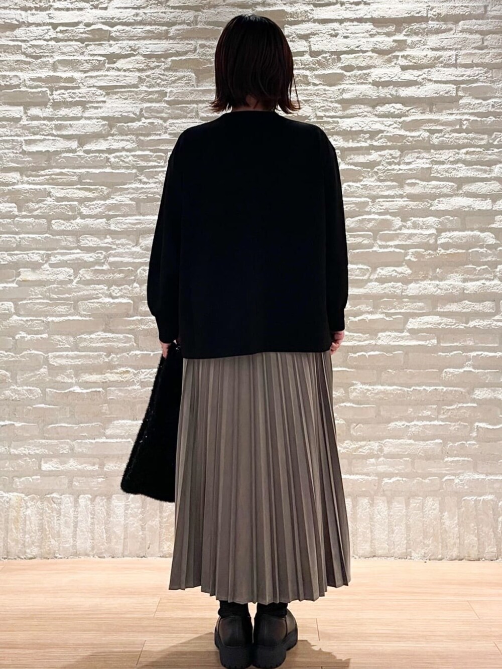ブラック系のTシャツ/カットソー、グレー系のスカート、ブラック系のハンドバッグを着用したレディースの秋コーディネートの3枚目の写真