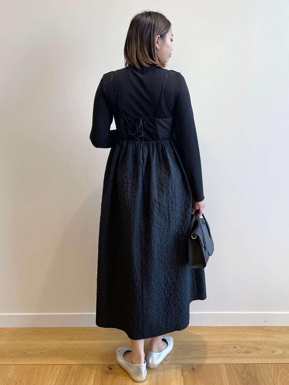 ブラック系のワンピース、ブラック系のTシャツ/カットソー、シルバー系のその他シューズを着用したレディースの冬コーディネートの3枚目の写真