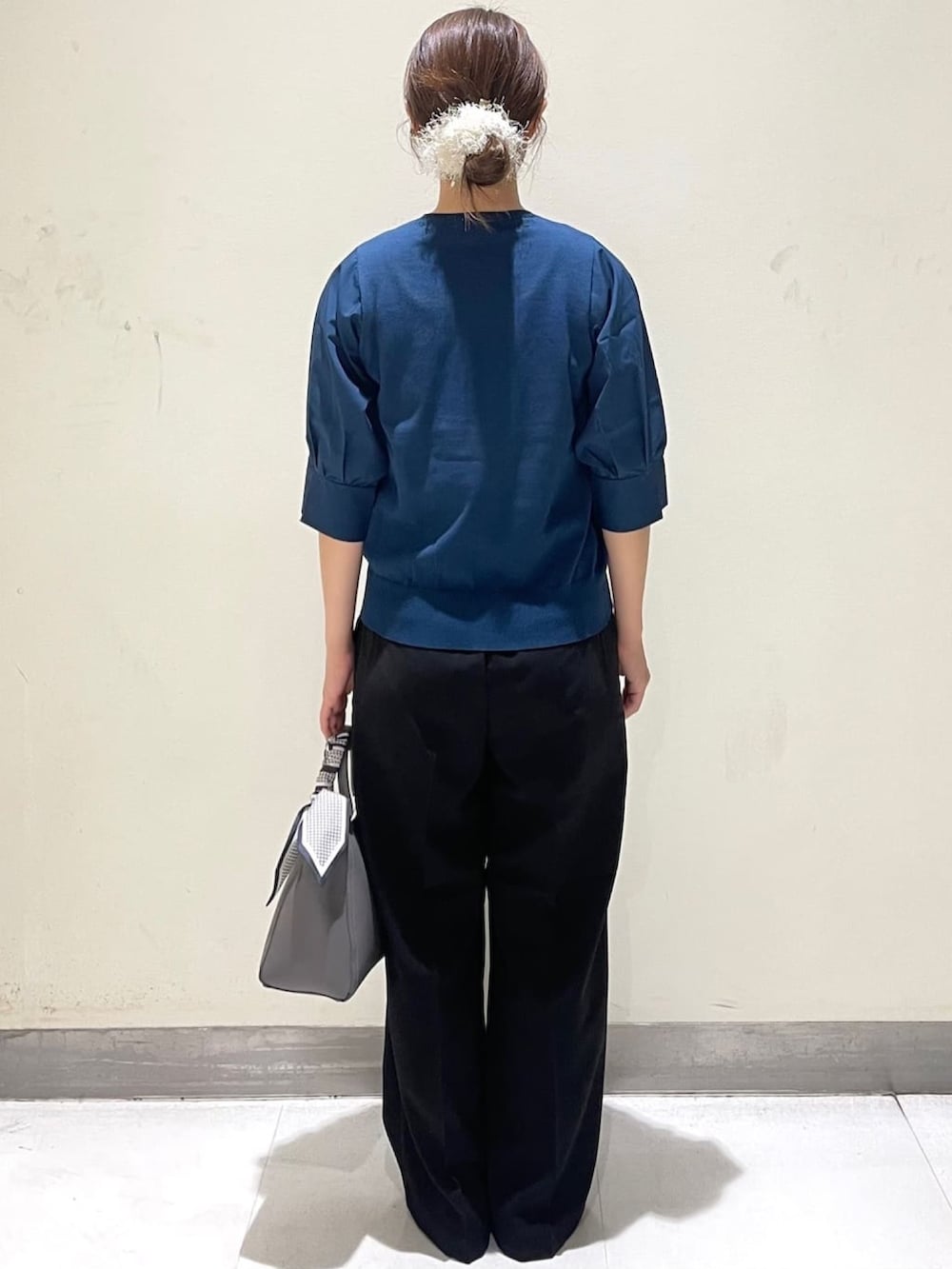 ブルー系のニット/セーター、ブラック系のその他パンツ、グレー系のトートバッグを着用したレディースの夏コーディネートの4枚目の写真