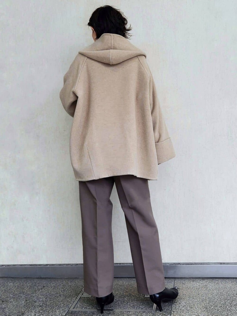 レッド系のニット/セーター、ブラウン系のその他パンツ、ベージュ系のその他アウターを着用したレディースの秋コーディネートの3枚目の写真