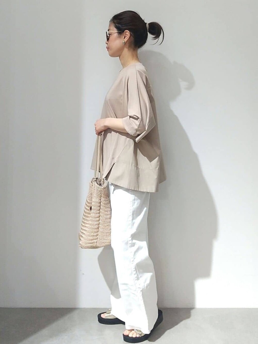 ベージュ系のTシャツ/カットソー、オレンジ系のカーディガン/ボレロ、ホワイト系のデニムパンツを着用したレディースの春コーディネートの7枚目の写真