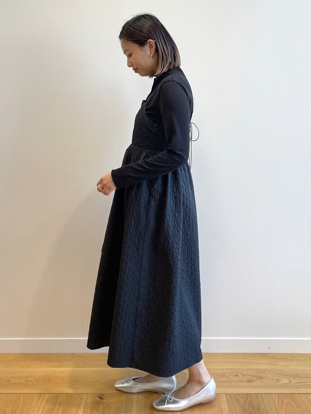 ブラック系のワンピース、ブラック系のTシャツ/カットソー、シルバー系のその他シューズを着用したレディースの冬コーディネートの2枚目の写真