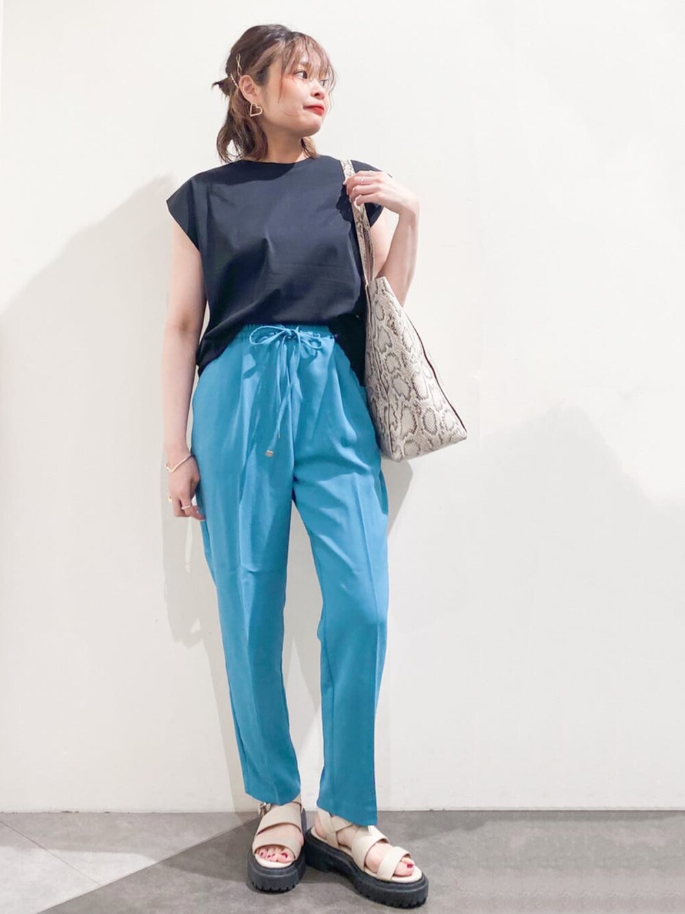 ブラック系のTシャツ/カットソー、ブルー系のその他パンツ、ベージュ系のトートバッグを着用したレディースの春コーディネートの2枚目の写真