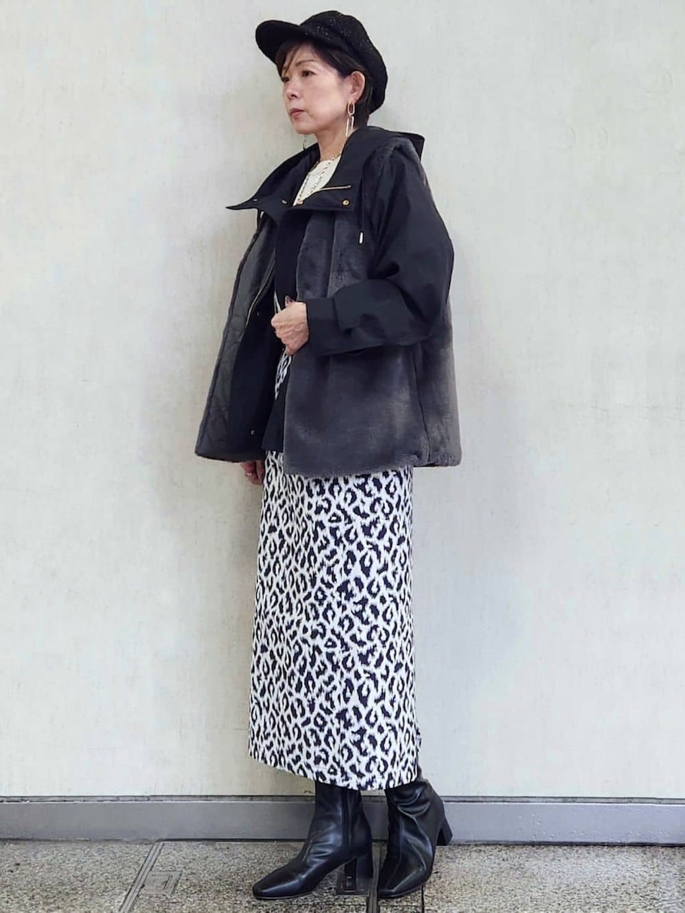 ブラック系のブルゾン、ブルー系のスカート、ブラック系のブーツを着用したレディースの秋コーディネートの3枚目の写真