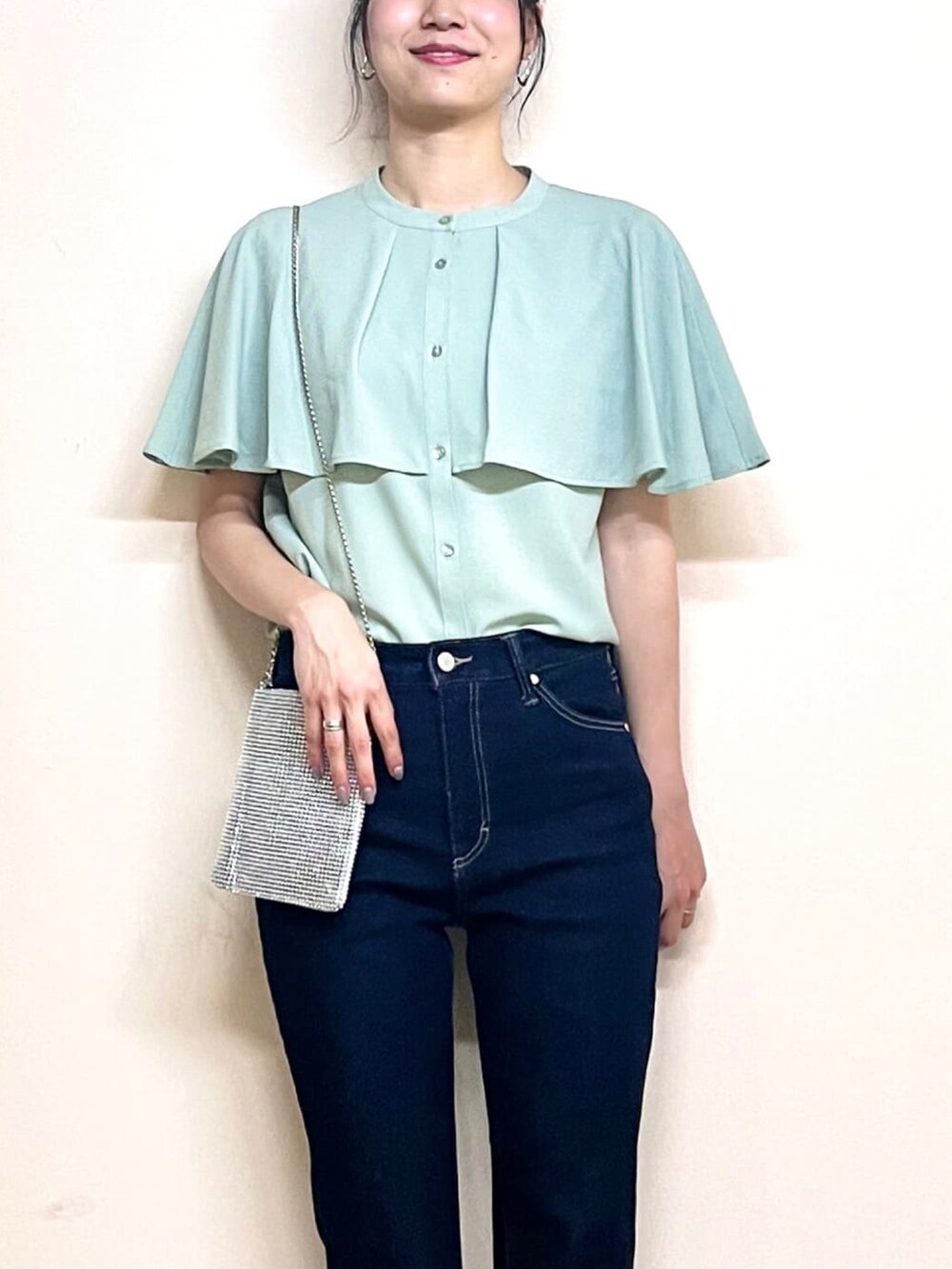 グリーン系のシャツ/ブラウス、ブラック系のパンプス、ブルー系のデニムパンツを着用したレディースの夏コーディネートの5枚目の写真