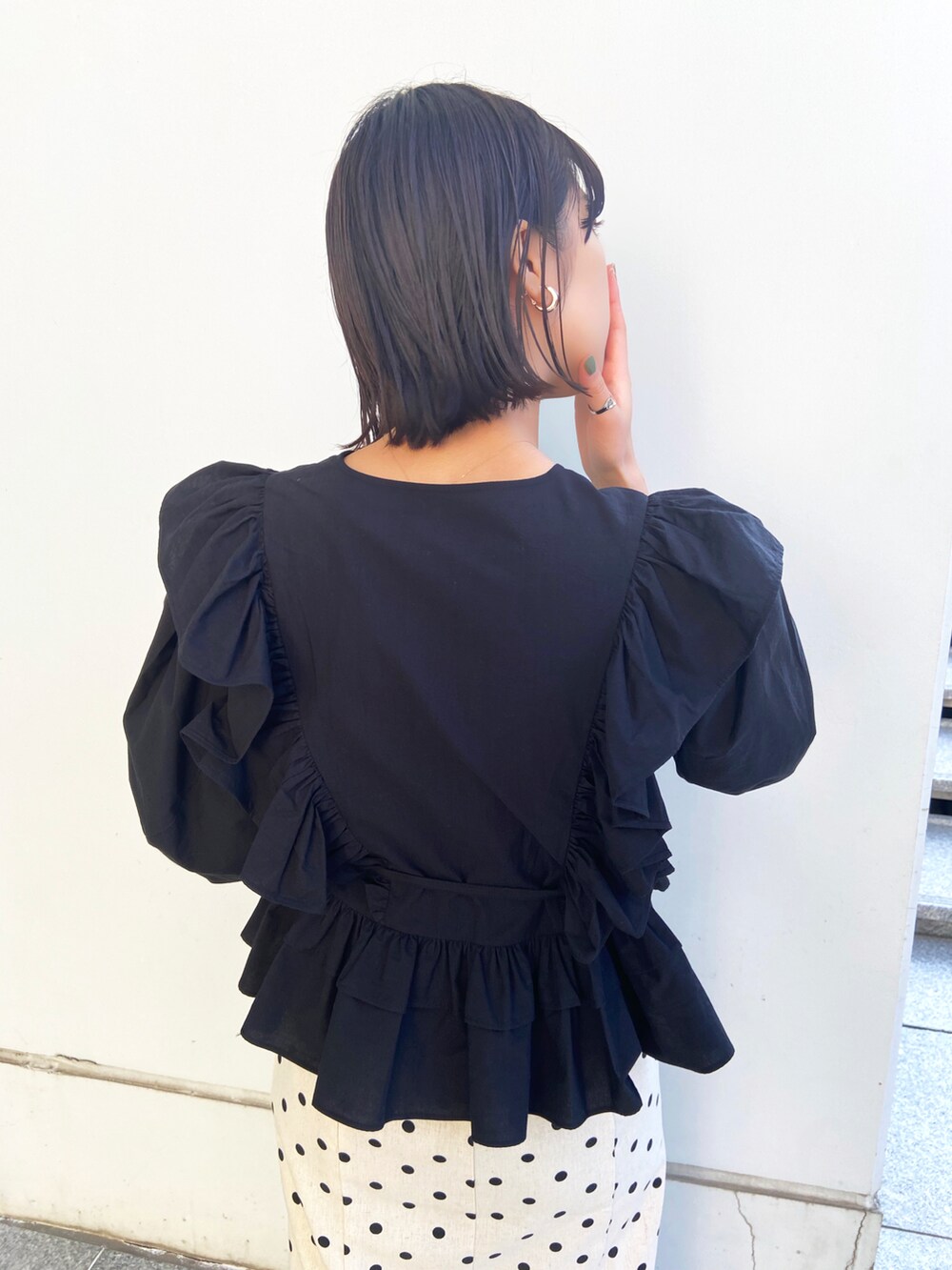 ブラック系のシャツ/ブラウス、ホワイト系のスカート、レッド系のパンプスを着用したレディースの春コーディネートの2枚目の写真