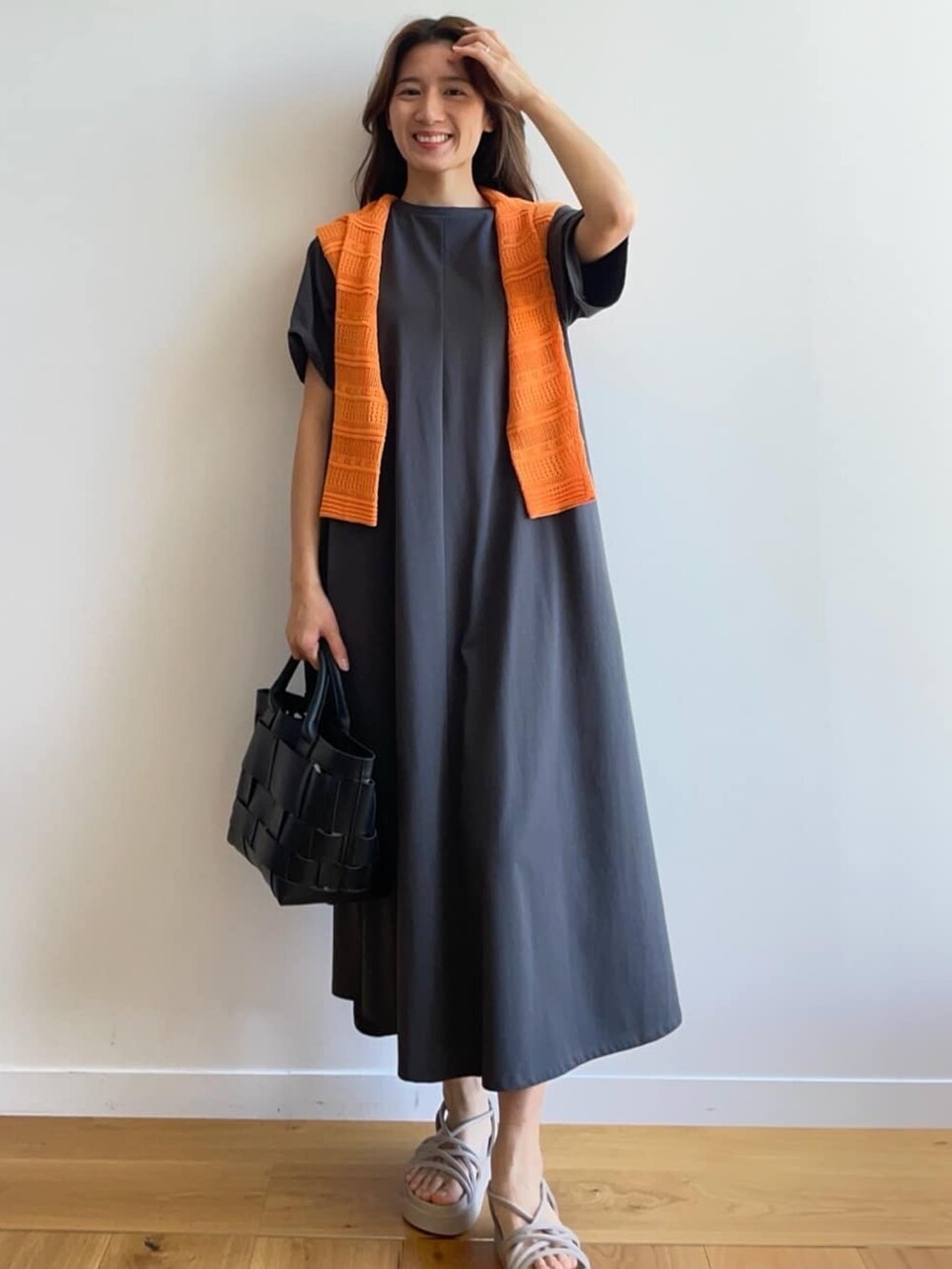 グレー系のワンピース、グレー系のサンダル、ブラック系のトートバッグを着用したレディースの春コーディネートの2枚目の写真