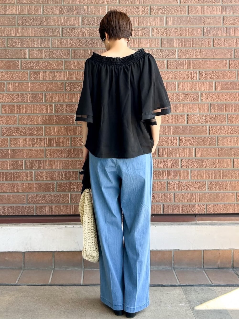 ブラック系のシャツ/ブラウス、ブラック系のサンダル、ベージュ系のショルダーバッグを着用したレディースの夏コーディネートの3枚目の写真