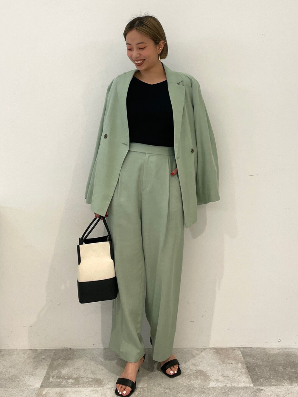 ブラック系のニット/セーター、グリーン系のテーラードジャケット、グリーン系のその他パンツを着用したレディースの春コーディネートの2枚目の写真