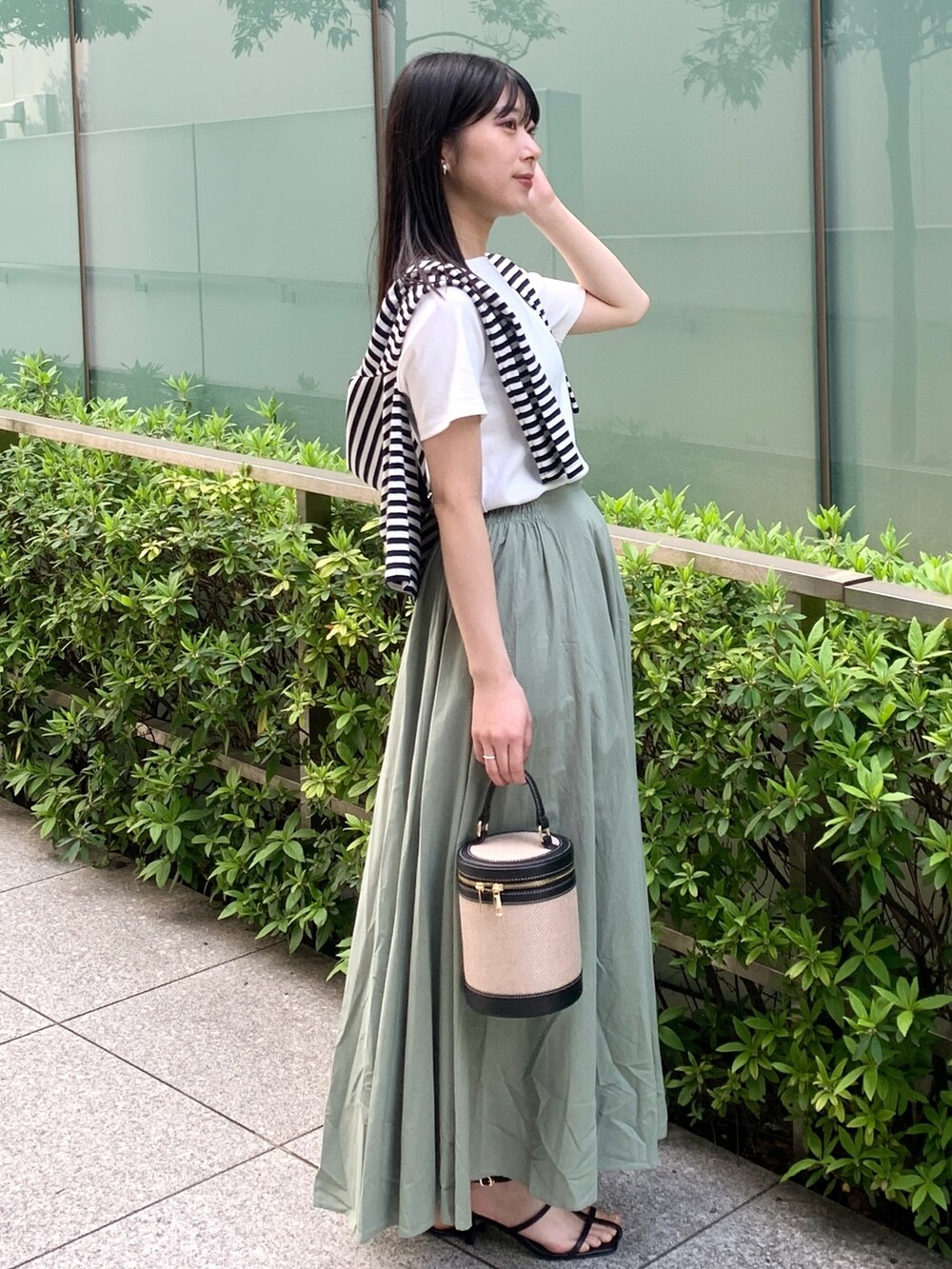 ホワイト系のTシャツ/カットソー、ホワイト系のカーディガン/ボレロ、グリーン系のスカートを着用したレディースの春コーディネートの2枚目の写真