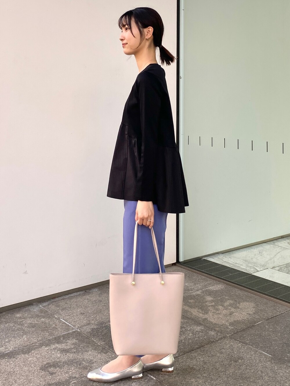 ブルー系のその他パンツ、ホワイト系のトートバッグ、ブラック系のTシャツ/カットソーを着用したレディースの冬コーディネートの2枚目の写真