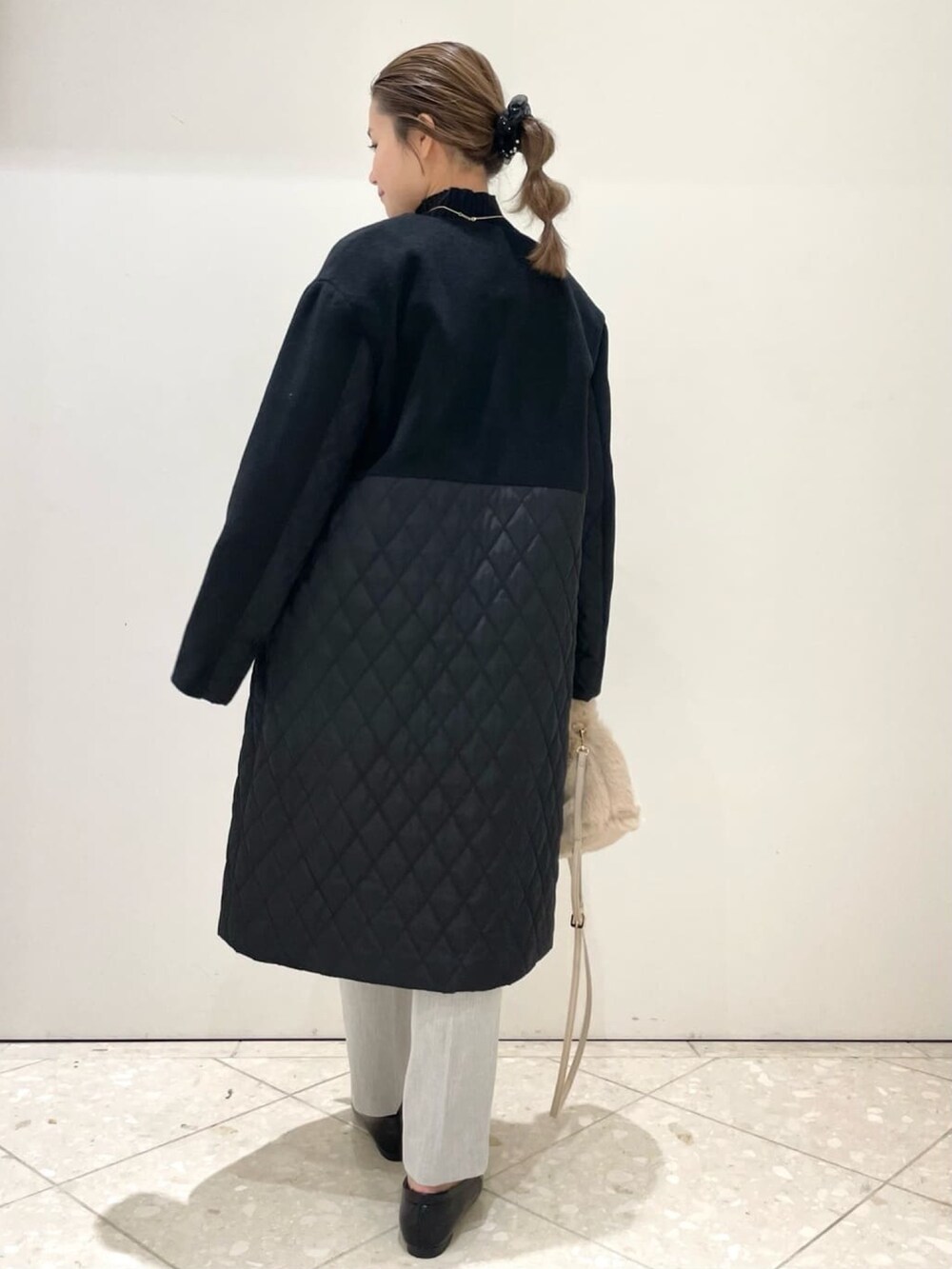 ブラック系のノーカラーコート、グレー系のその他パンツ、ブラック系のパンプスを着用したレディースの冬コーディネートの4枚目の写真