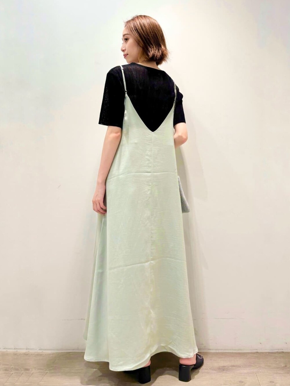 ブラック系のニット/セーター、グリーン系のワンピース、シルバー系のショルダーバッグを着用したレディースの夏コーディネートの5枚目の写真