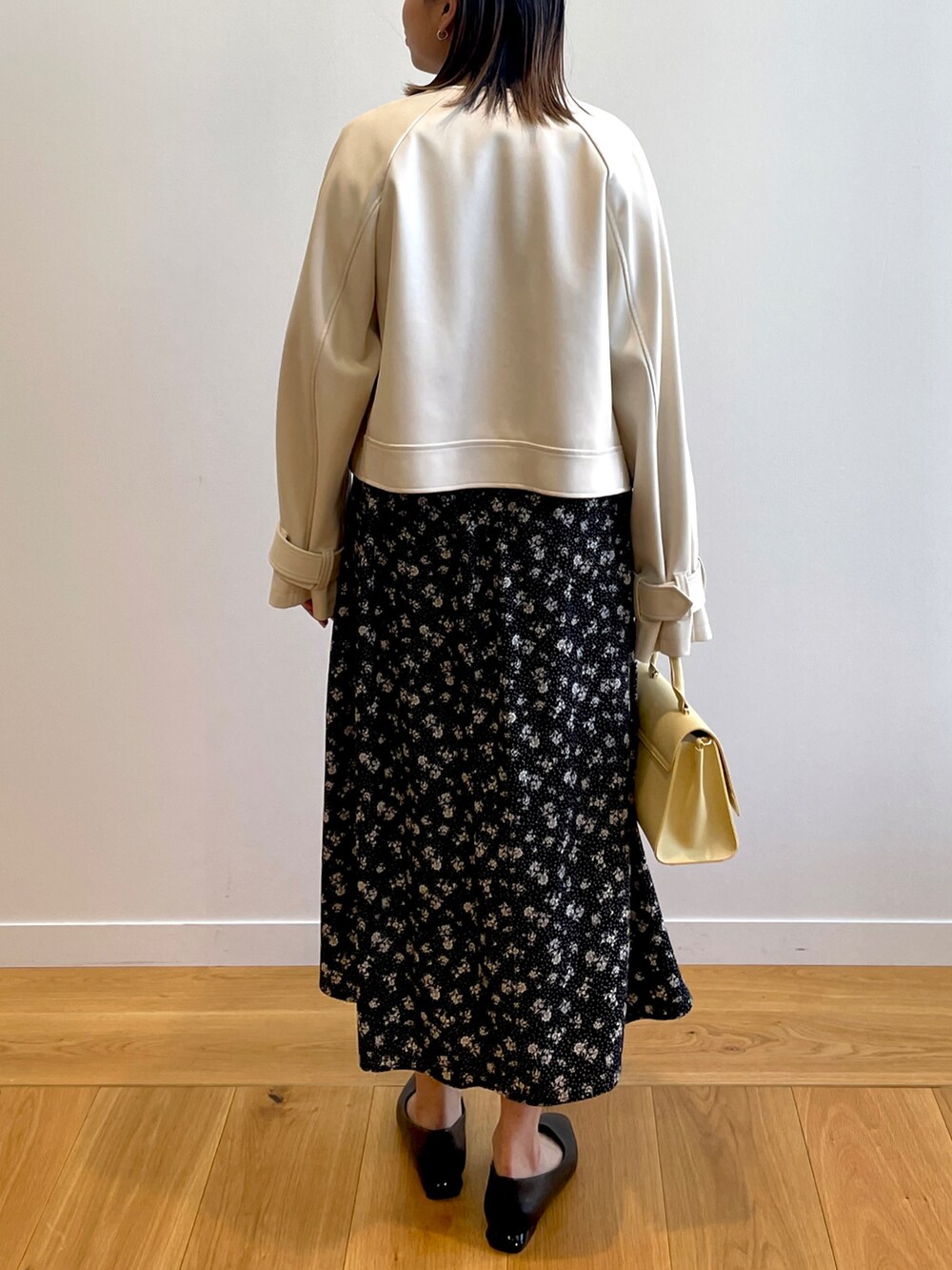 ベージュ系のノーカラージャケット、ブラック系のワンピース、イエロー系のショルダーバッグを着用したレディースの春コーディネートの3枚目の写真