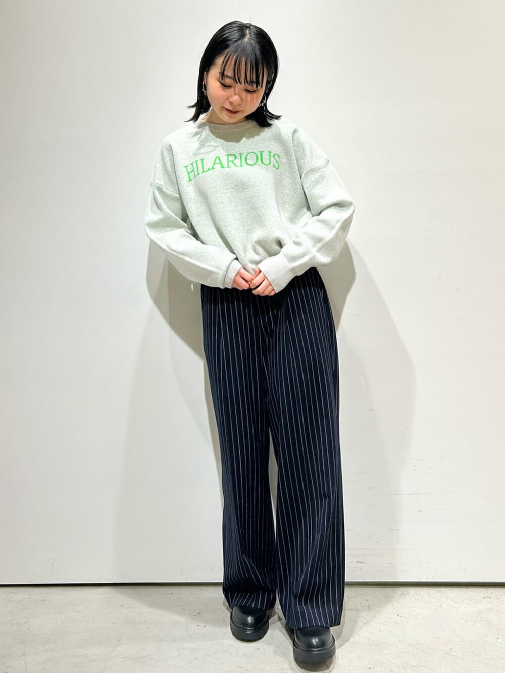 ブラック系のカーディガン/ボレロ、グレー系のニット/セーター、ブラック系のブーツを着用したレディースの冬コーディネートの2枚目の写真