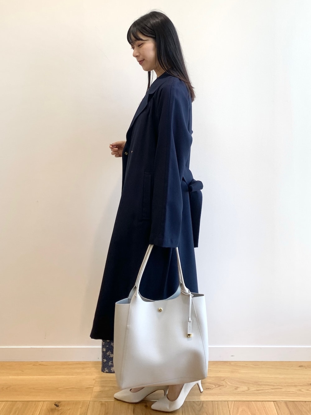 ブルー系のトレンチコート、ブルー系のワンピース、グレー系のトートバッグを着用したレディースの春コーディネートの2枚目の写真