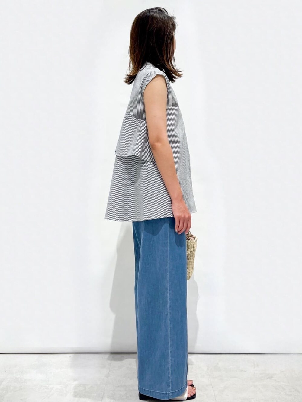 ホワイト系のシャツ/ブラウス、ホワイト系のサンダル、ゴールド系のショルダーバッグを着用したレディースの夏コーディネートの6枚目の写真