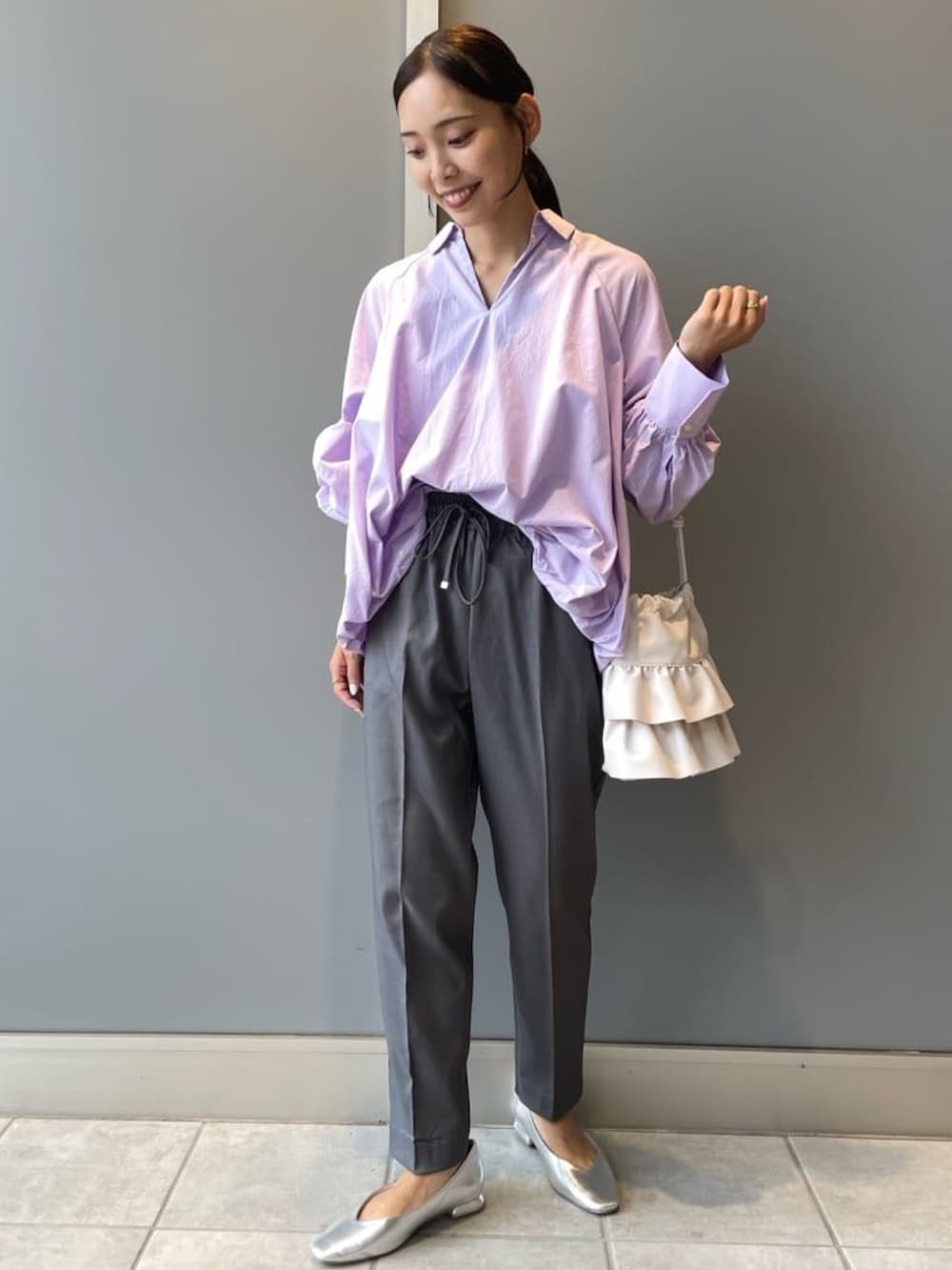 パープル系のシャツ/ブラウス、グレー系のその他パンツ、ホワイト系のショルダーバッグを着用したレディースの秋コーディネートの3枚目の写真