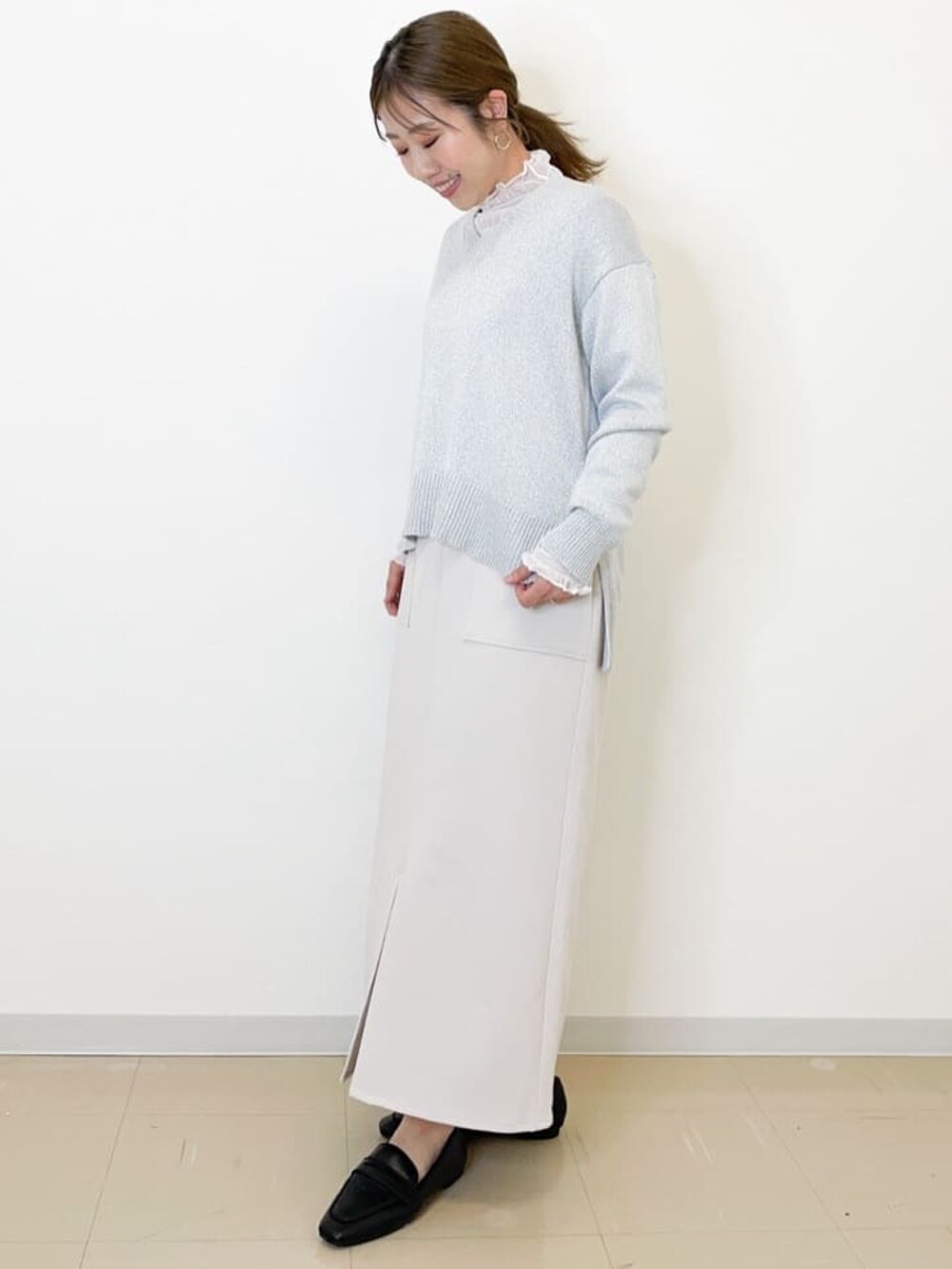 ホワイト系のニット/セーター、ベージュ系のスカート、ホワイト系のTシャツ/カットソーを着用したレディースの春コーディネートの2枚目の写真