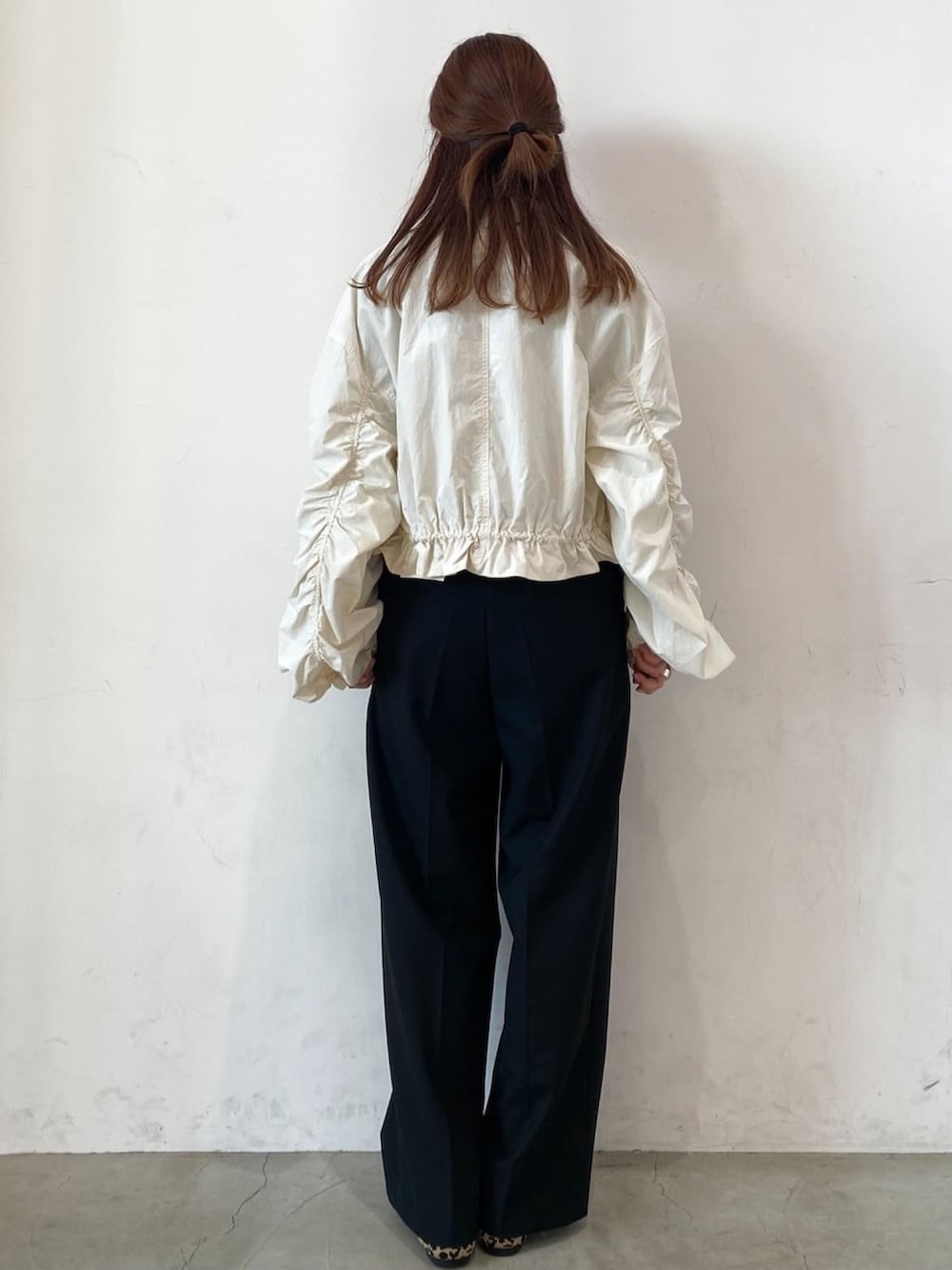 ホワイト系のブルゾン、ブラック系のその他パンツ、ベージュ系のTシャツ/カットソーを着用したレディースの春コーディネートの3枚目の写真