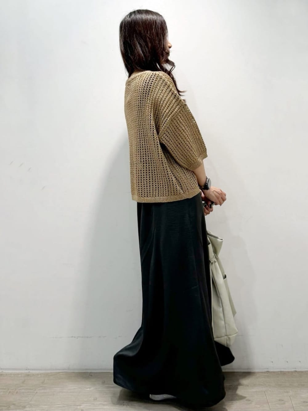 ゴールド系のニット/セーター、グレー系のトートバッグ、グレー系のスカートを着用したレディースの秋コーディネートの6枚目の写真